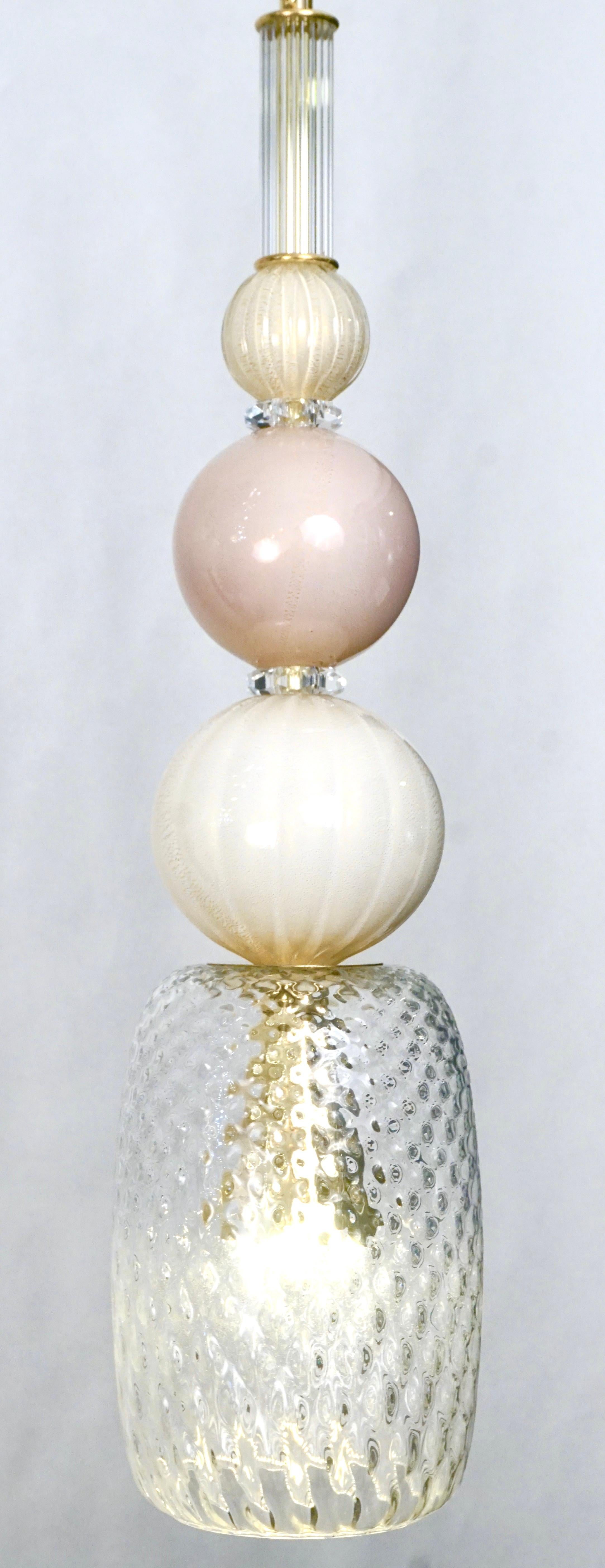 L'amusant et élégant lustre-lanterne italien, entièrement fabriqué à la main, de conception organique moderne, composé d'une succession d'éléments : cylindre en verre de Murano en cristal anglés, sphères en verre opalin rose blush et blanc ivoire