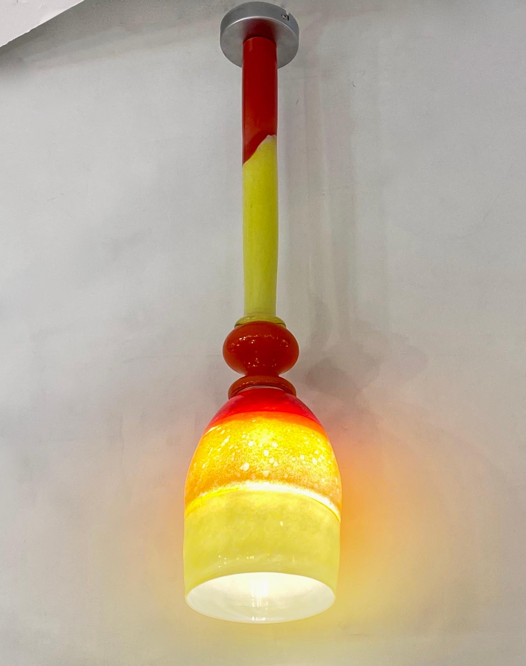 Fun and elegant Italian contemporary custom-made chandelier pendant light, entirely handmade, of organic modern design consisting of a blown Murano glass shade in 3 colors: red, yellow, and orange, fused with the difficult incalmo technique, the