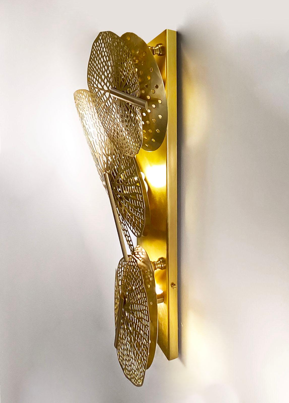 The brass leaves of different sizes on this Art Deco Design sculpture sconce introduce nature into your interior and this is in itself a unique Work of Art, entirely handcrafted, engraved, and laser-cut. Concealing pierced concave discs hide a brass