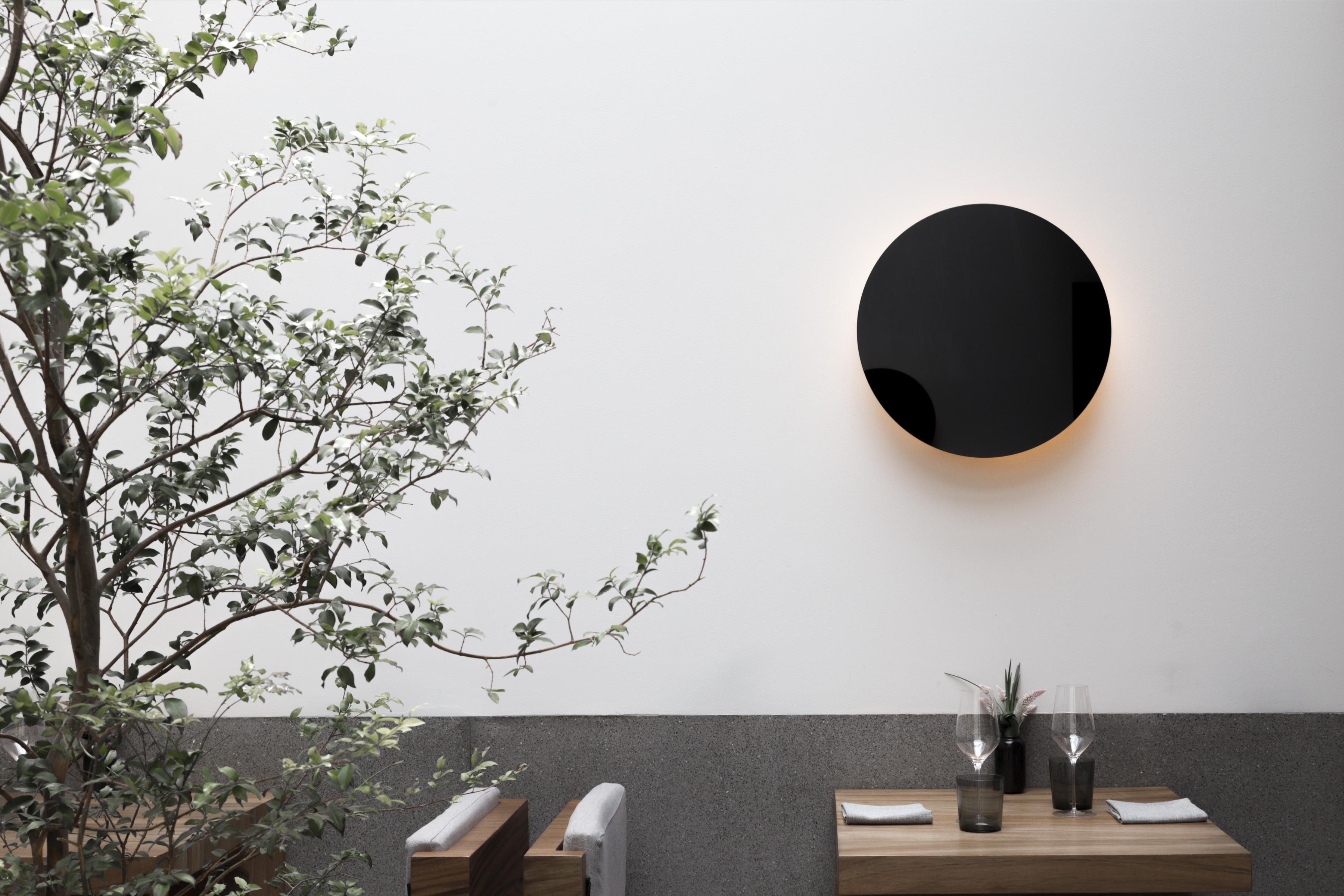 Eclipse sconce Lamp: simple and elegant. Strong geometry of the black glass circle is lit with LEDs from within, emits a warm glow and atmospheric light. 

Dimmable upon request