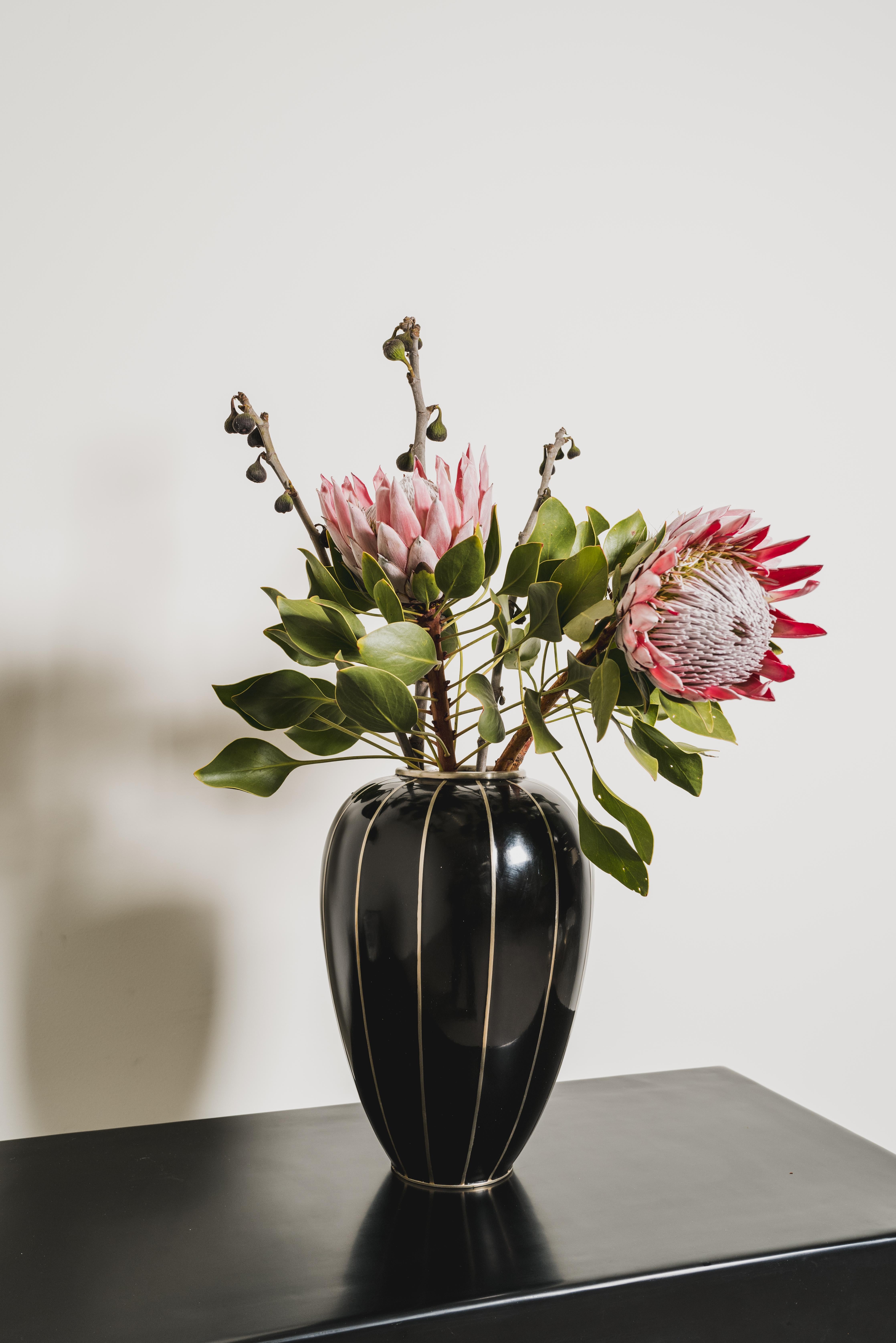Baluster-Vase mit weiß-bronzefarbenen Streifen
Schwarzer Lack 
Weiß-Bronze-Streifen
Hand Repoussé
Limitierte Auflage
Zeitgenössisch
Jedes Stück wird individuell angefertigt und ist einzigartig. 

Lack ist eine Technik, die auf die Shang-Dynastie