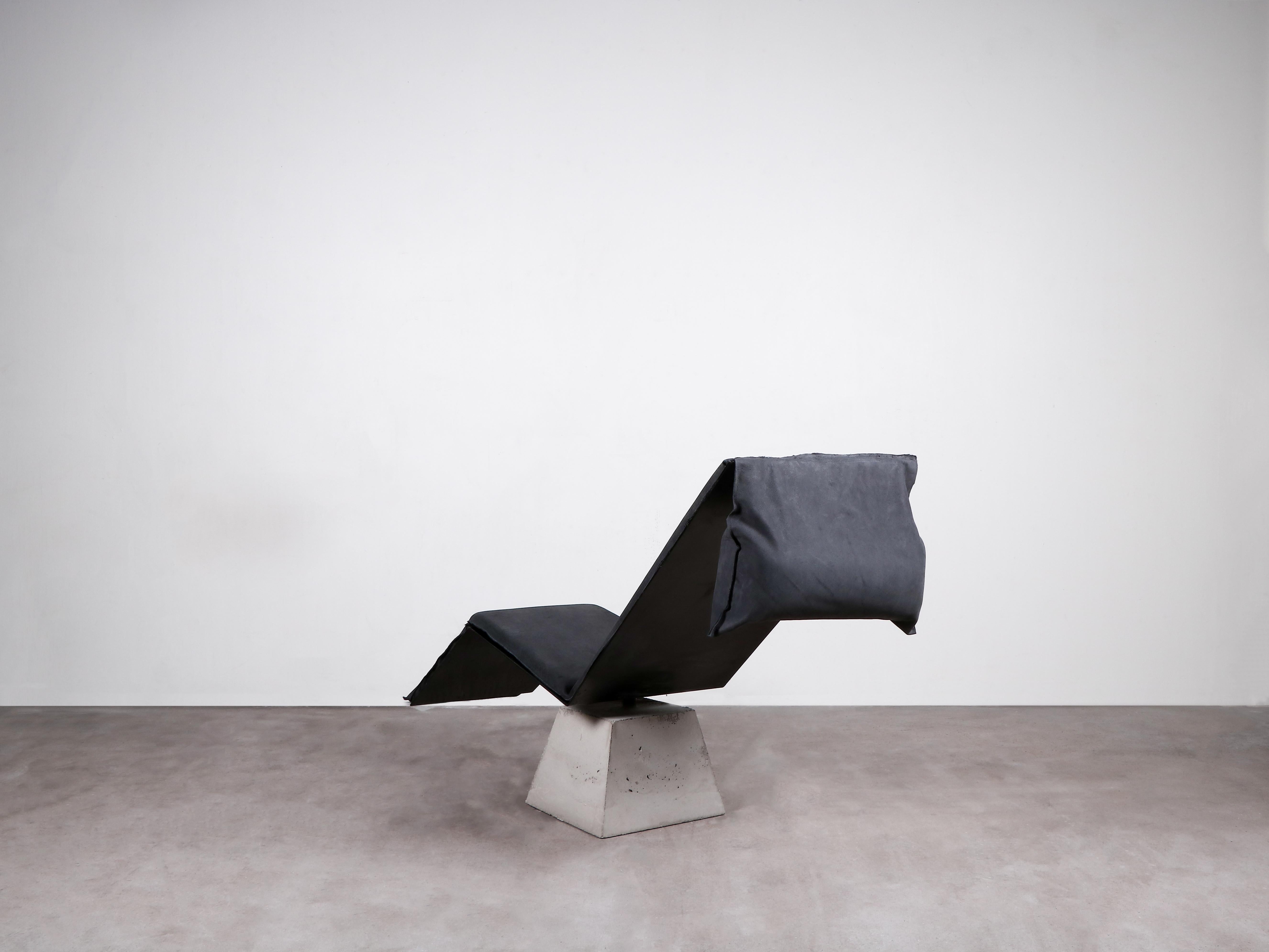 Contemporary black lounge chair / chaise lounge - Flykt chair by Lucas Morten

2020
Limited edition of 18 + 1 AP
Dimensions (cm): L 150 H 83 W 50
Material: concrete, burned waxed steel and hand-waxed upholstered cushion color/black and
