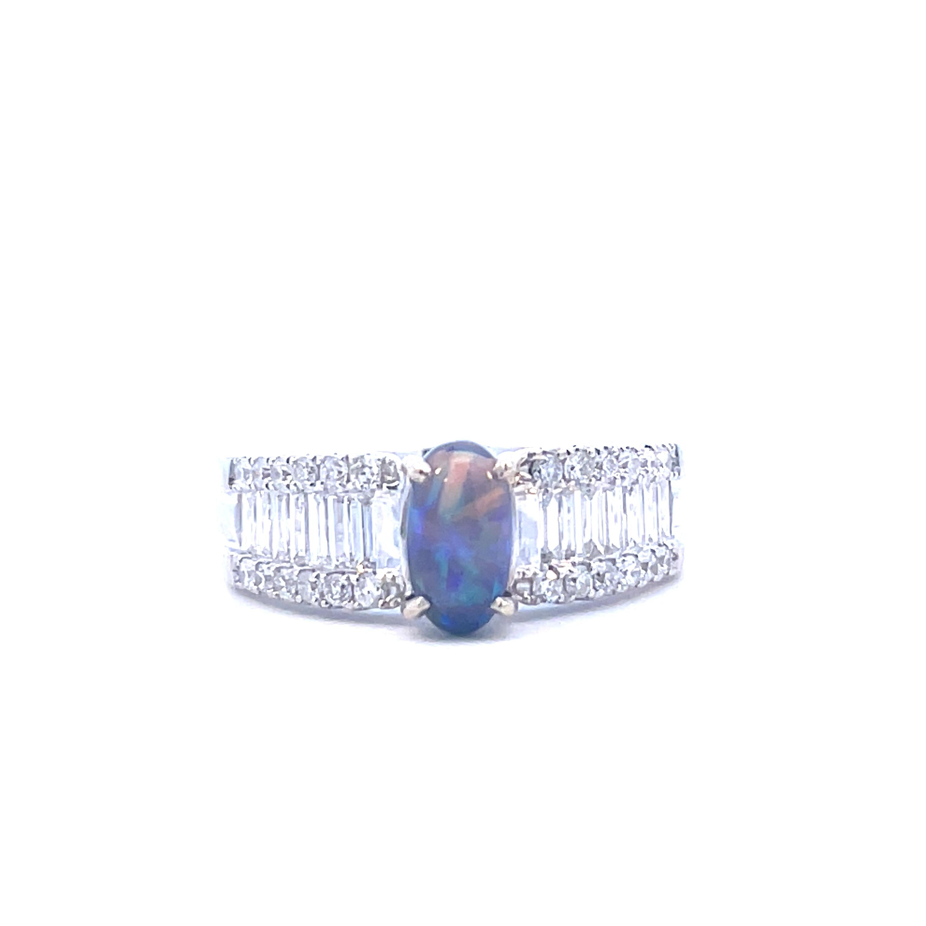 This is a breathtaking 18K white gold and black opal ring set with breathtaking baguette and round diamonds cascading down the sides. The stunning black opal set in this ring will put you in a trance! The color play on the opal is remarkable, and