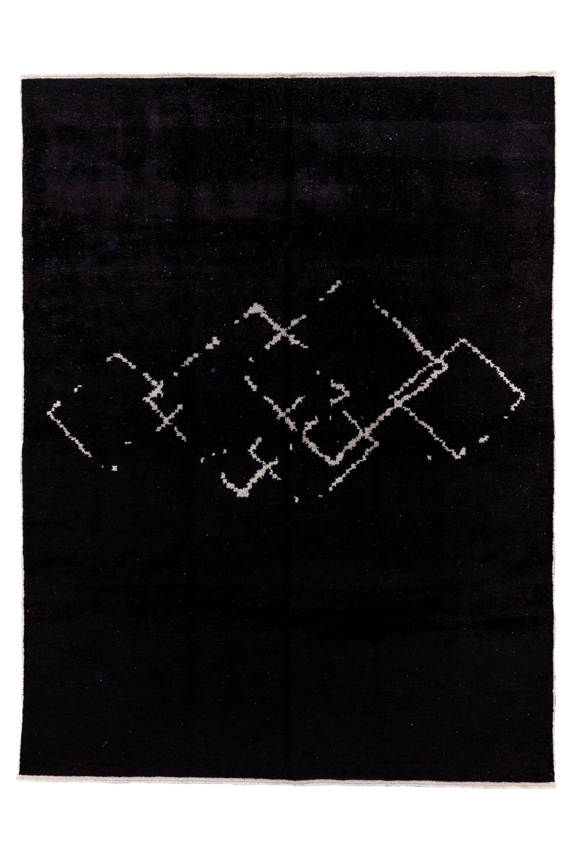 The borderless charcoal black field  displays painterly brushstroke pattern in ecru across the horizontal centre of the piece. The pattern is four partially overlaid broken open lozenges. Moderate  weave. Moderate pile. As new condition.

Rug
