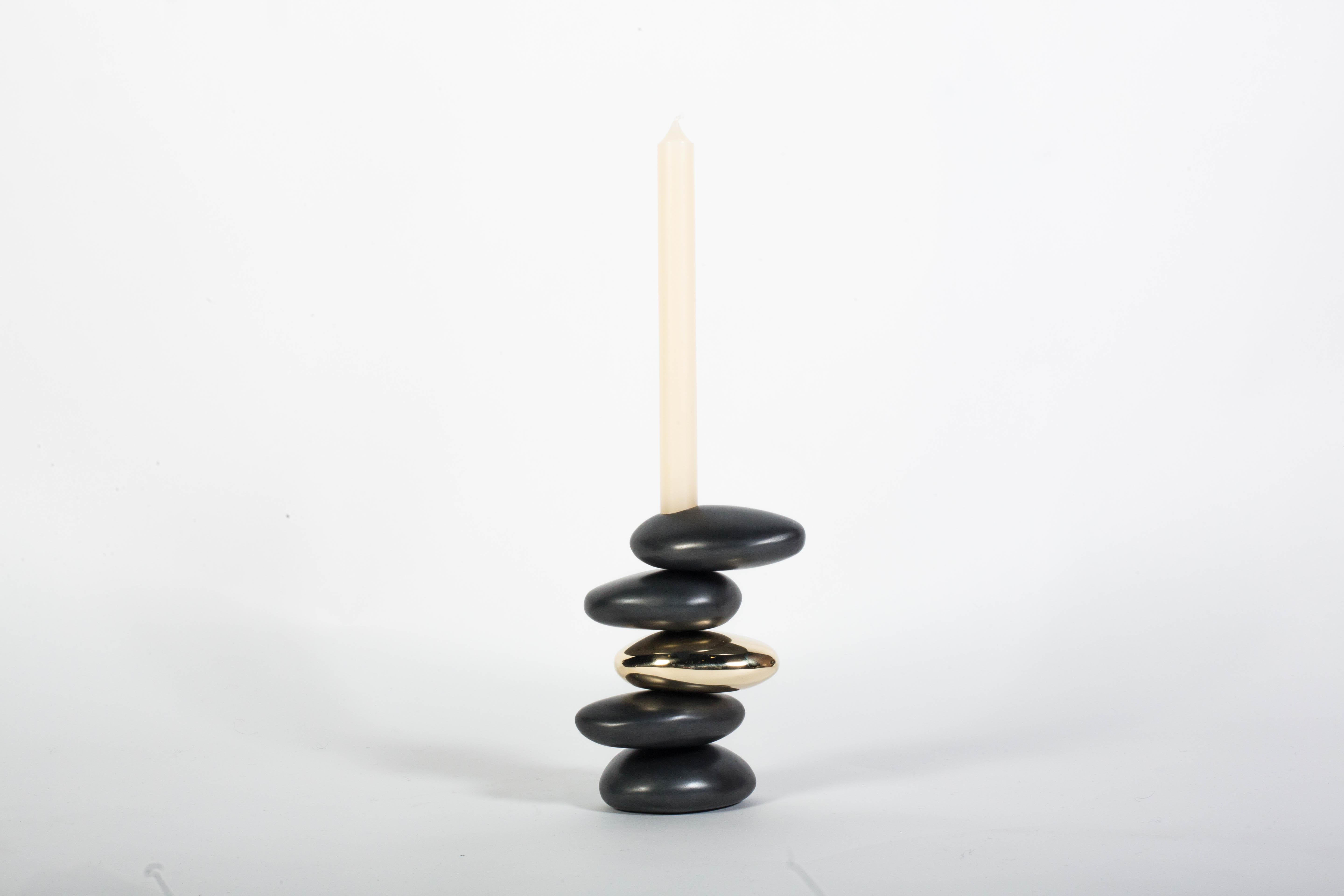 This blackened and polished solid brass candleholder is inspired by the curves and contours of stones shaped by the ocean. Cast at a Pennsylvania foundry from hand-shaped forms, each stacked 'stone' has a different shape. Finished by hand. Also