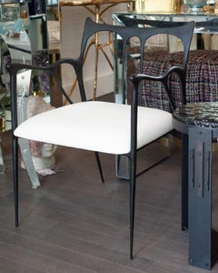 Poltrona scultorea contemporanea in ottone fuso annerito con seduta in calico