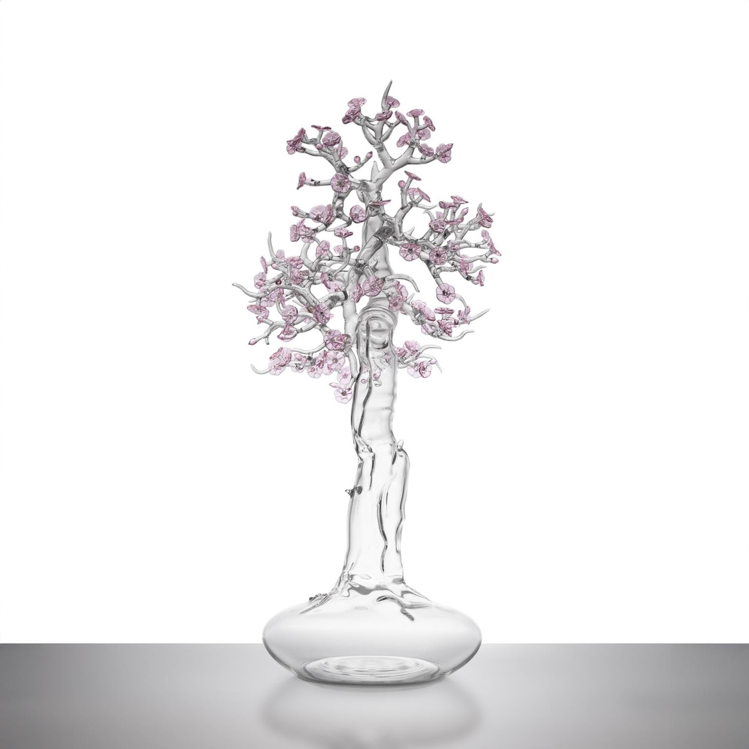 Ti presentiamo una squisita scultura in vetro soffiato a mano che rappresenta un bonsai in fiore, realizzata magistralmente dal rinomato artista italiano Simone Crestani. Questa splendida scultura racchiude la delicata bellezza e il profondo