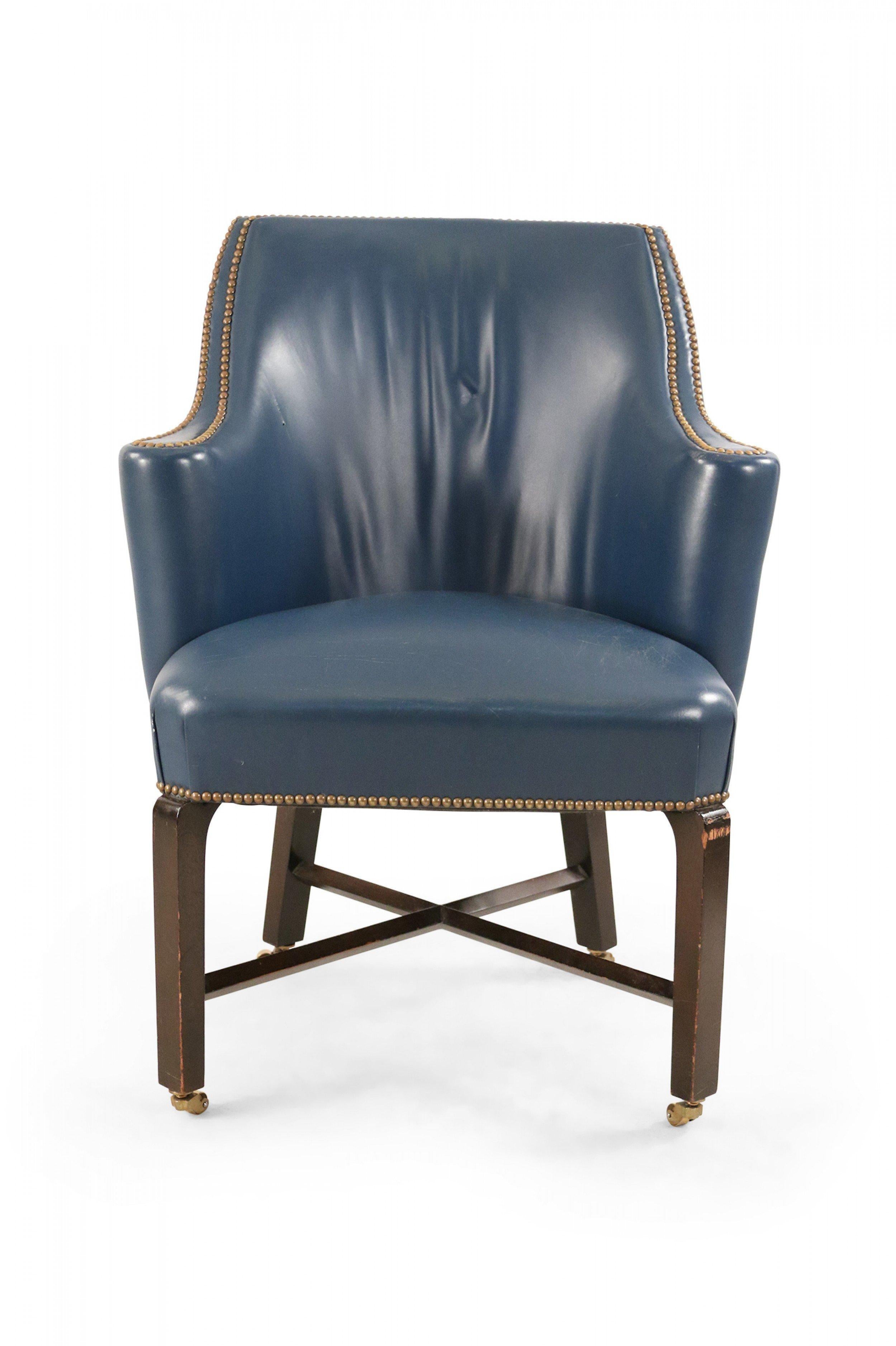 Contemporary blue leather club / armchair with a rounded back, black painted wooden legs on small casters with an x-shaped stretcher, and brass upholstery nail detail.