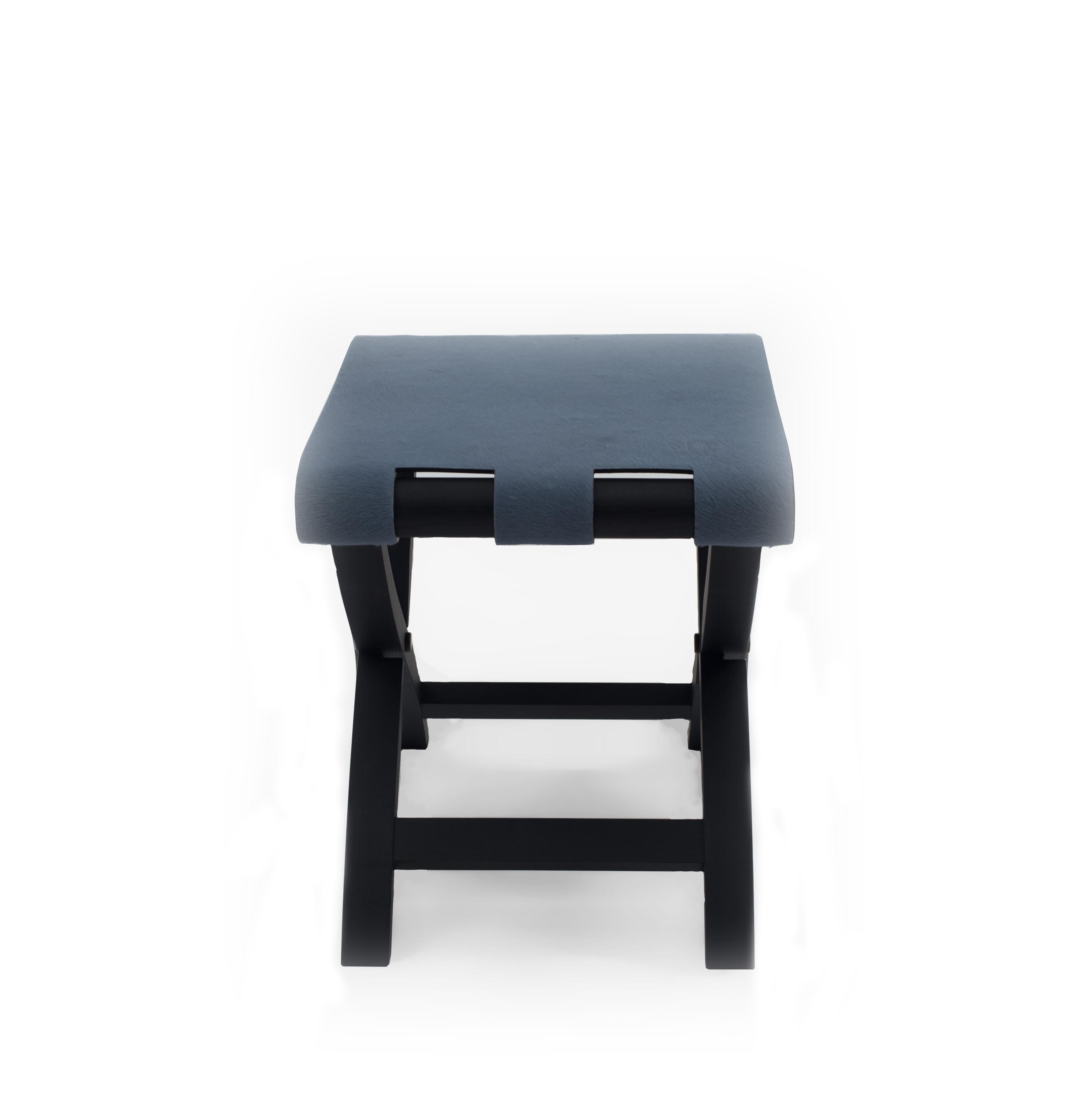 Contemporary Italian folding stool / luggage rack with a black base and cornflower blue pony hair seat.
 