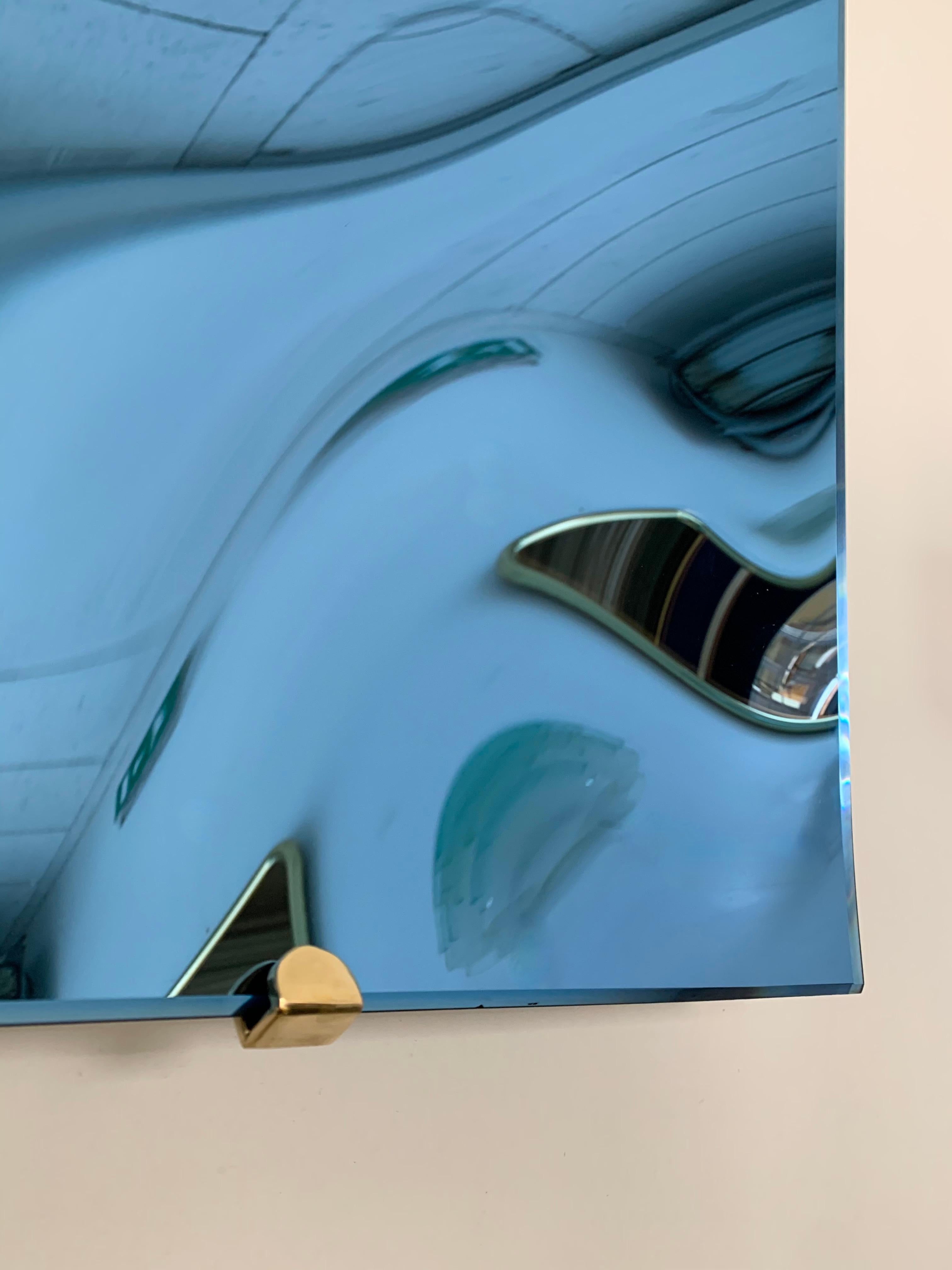 Zeitgenössische quadratische Kurve konkave Skulptur blauer Wandspiegel, Messingstruktur. Kunsthandwerkliche, handgefertigte Arbeiten aus einer kleinen italienischen Werkstatt, die die alte Technik der Mercurisation verwendet.