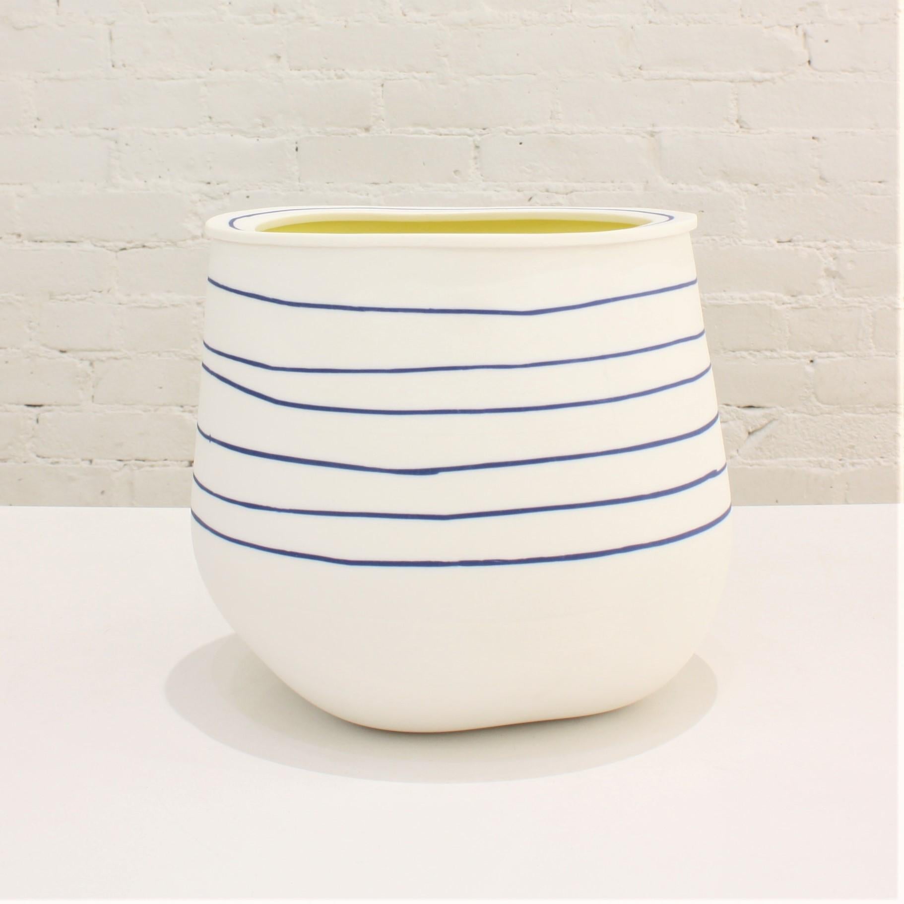 One-of-a-kind slab-built porcelain vase with blue stripes with vivid yellow interior. Well-known ceramicist Eric Hibelot decorates his porcelain vessels with bold primary colors, in the pop art tradition.

Hand-painted. Signed by the