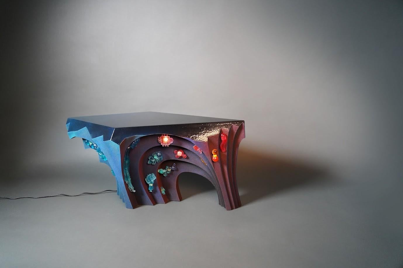 COLLECTION'S
s'inspire de la nature surréaliste des rêves. Fabriquée à partir de sable de quartz noir et de résine, cette collection incarne le jeu délicat entre la lumière et l'obscurité, la transparence et l'opacité. Enracinant l'œuvre dans le