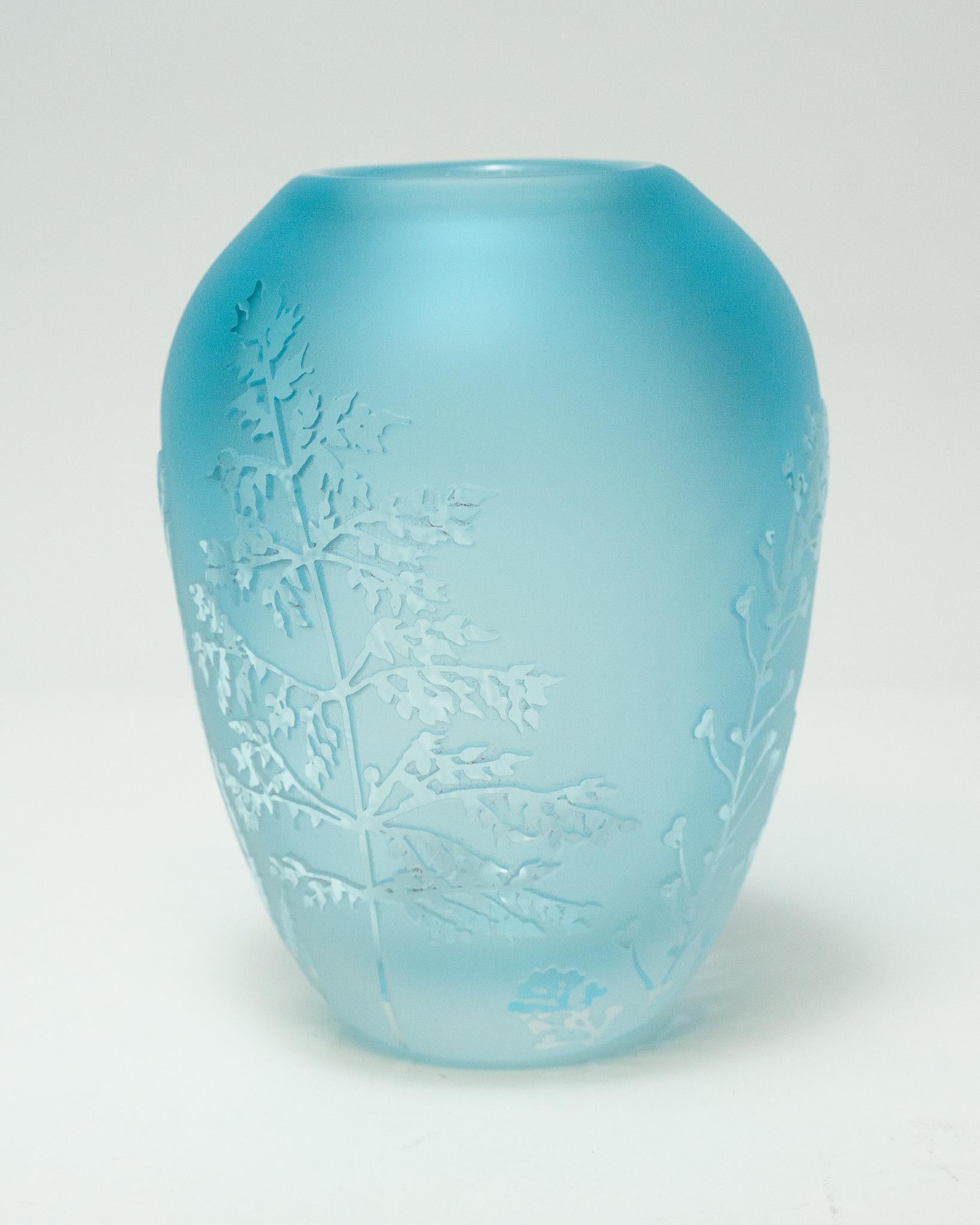 A stunning contemporary blue blown glass vase with sandblasted surface and raised cut glass botanical motifs by a Canadian artist.