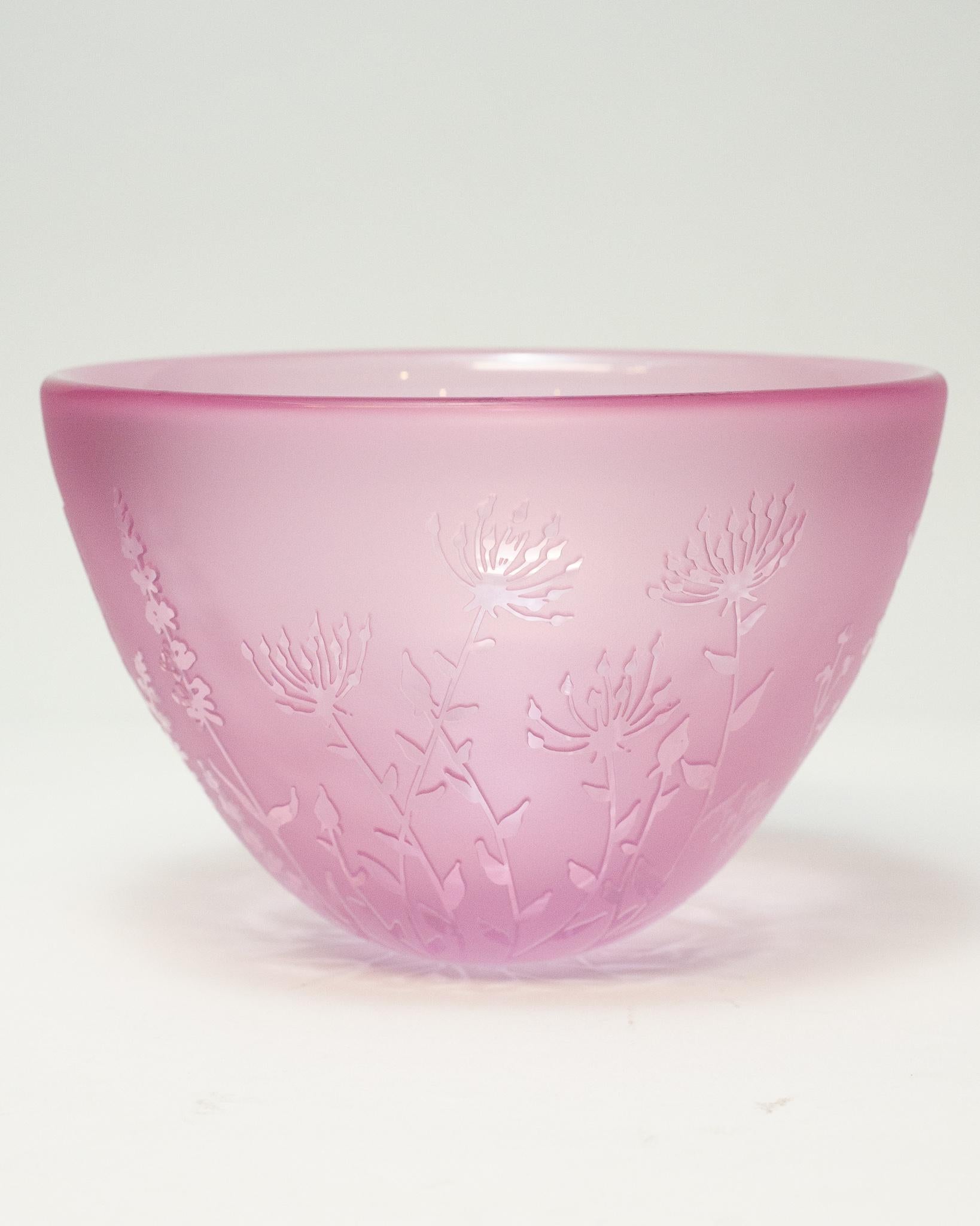 A stunning contemporary pink blown glass bowl with sandblasted surface and raised cut glass botanical motifs by a Canadian artist.