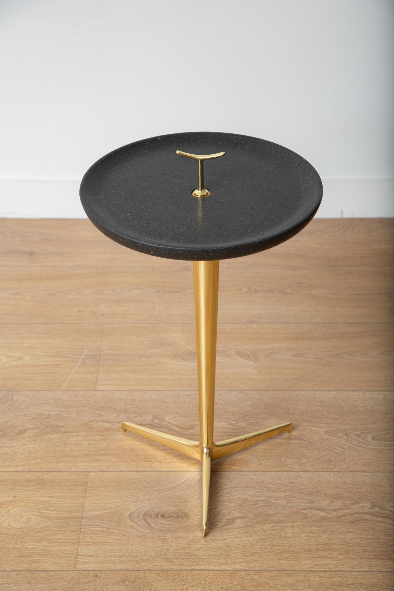 Contemporary brass and lava stone top drinks or side table
Polished brass structure with 3-pronged foot 
Beveled lava stone top with stylized finial 
Available to view in-situ in our Miami gallery.

 