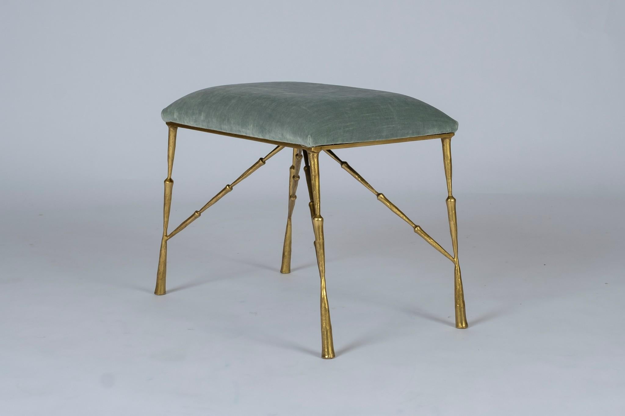 A contemporary brass ottoman upholstered in a striated pale aqua green velvet. Also available C.O.M.