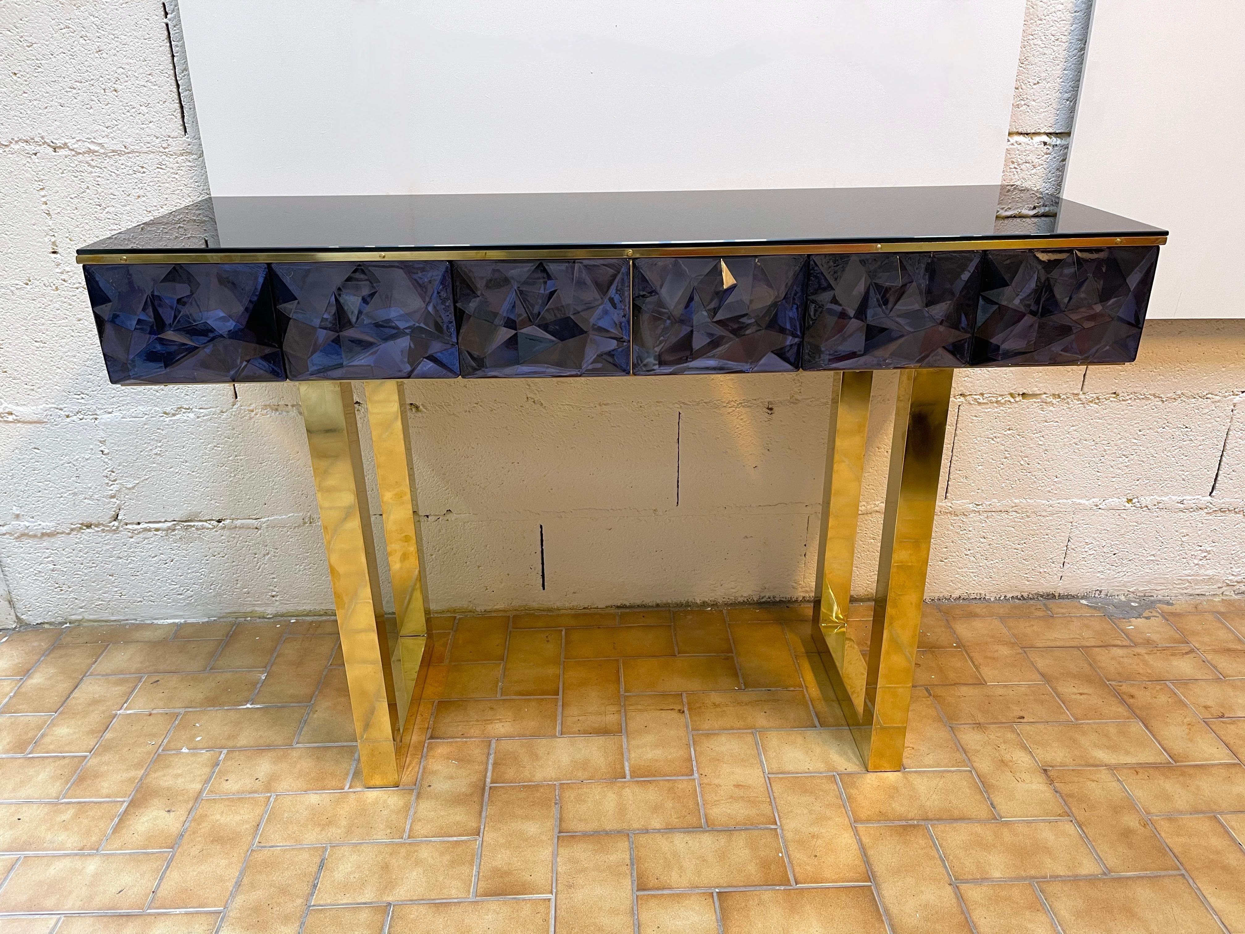 Contemporary console, full brass and large pieces of blue Murano glass with relief diamond point. Black opaline color glass top. Small artisanal workshop. The mirror same model is available.