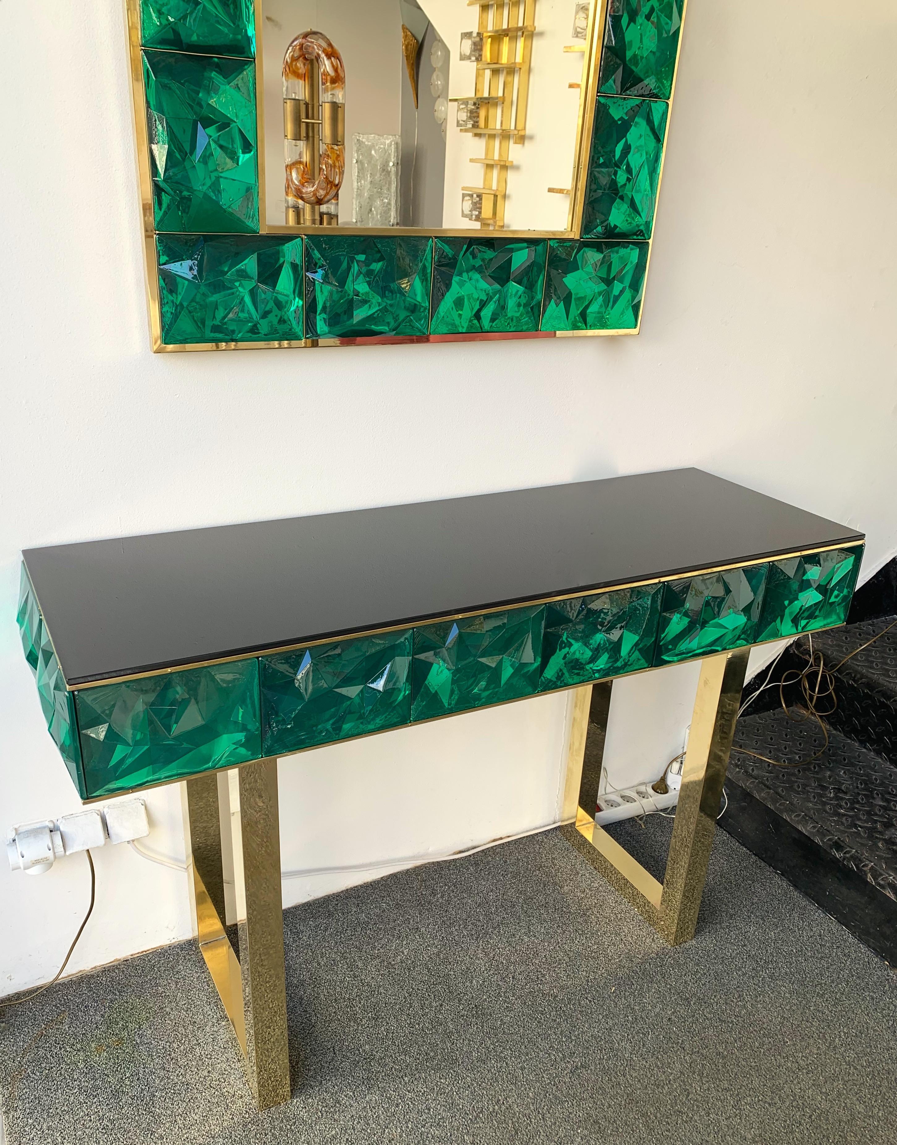 Contemporary wall mirror and console set, full brass and large pieces of green emerald Murano glass with relief diamond point. Small artisanal workshop. The mirror can be hang horizontally also.

Measurements in description for the mirror
Console