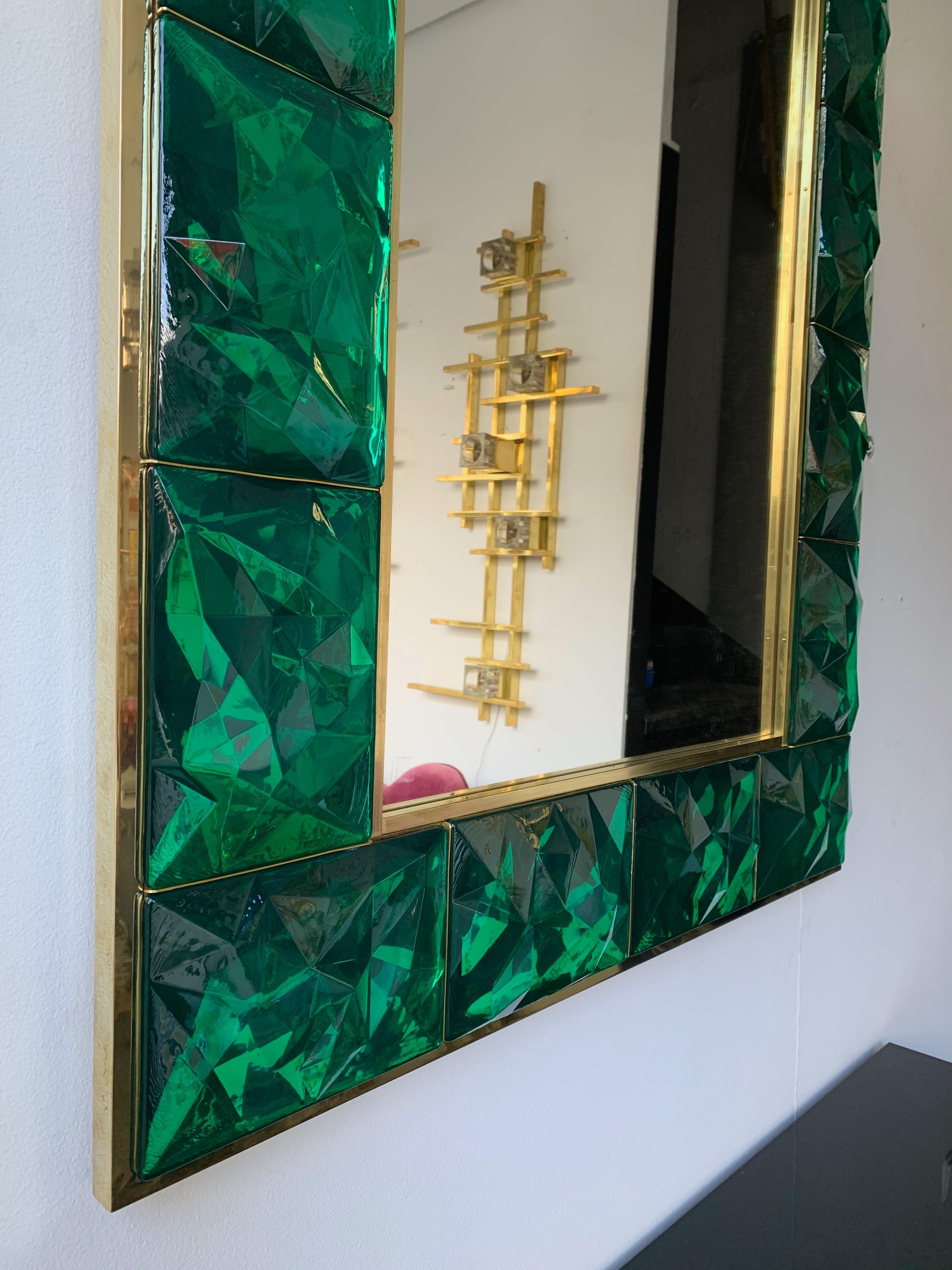 Contemporary wall mirror, full brass and large pieces of green emerald Murano glass with relief diamond point. Small artisanal workshop. The mirror can be hang horizontally also. The console table same model is available.