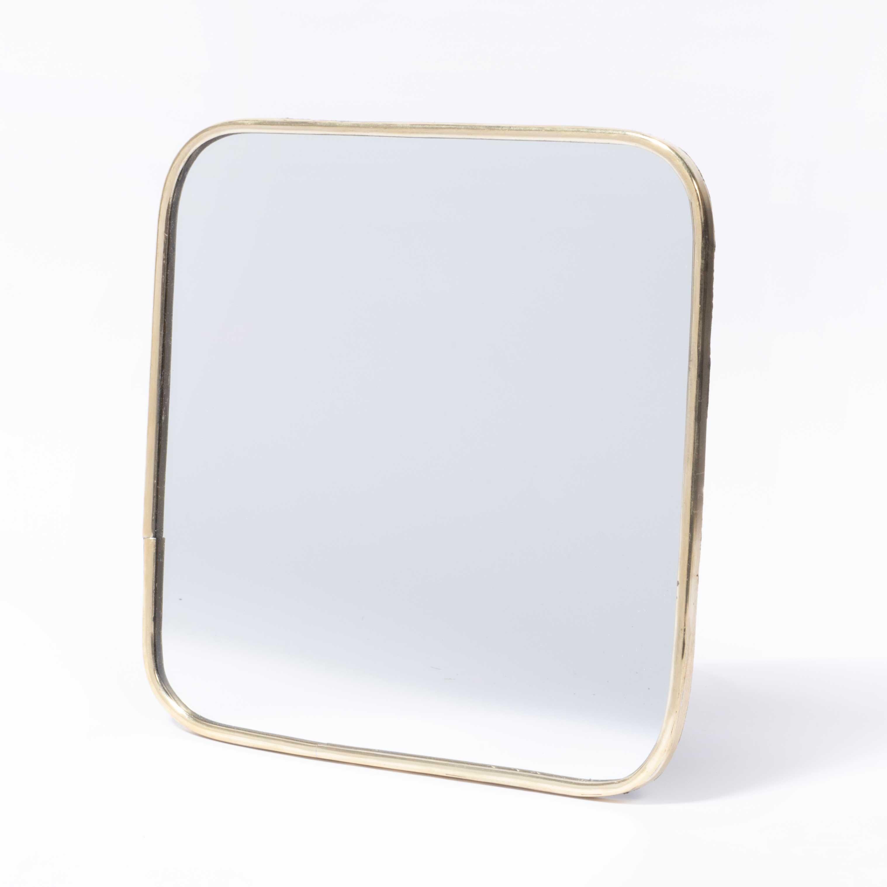 Specchio contemporaneo in ottone - Piccolo. 

Realizzata a mano per noi in Marocco, ha un design contemporaneo con una semplice struttura in ottone e un retro in tessuto. Il pannello posteriore presenta due semplici occhielli per essere appeso, ma