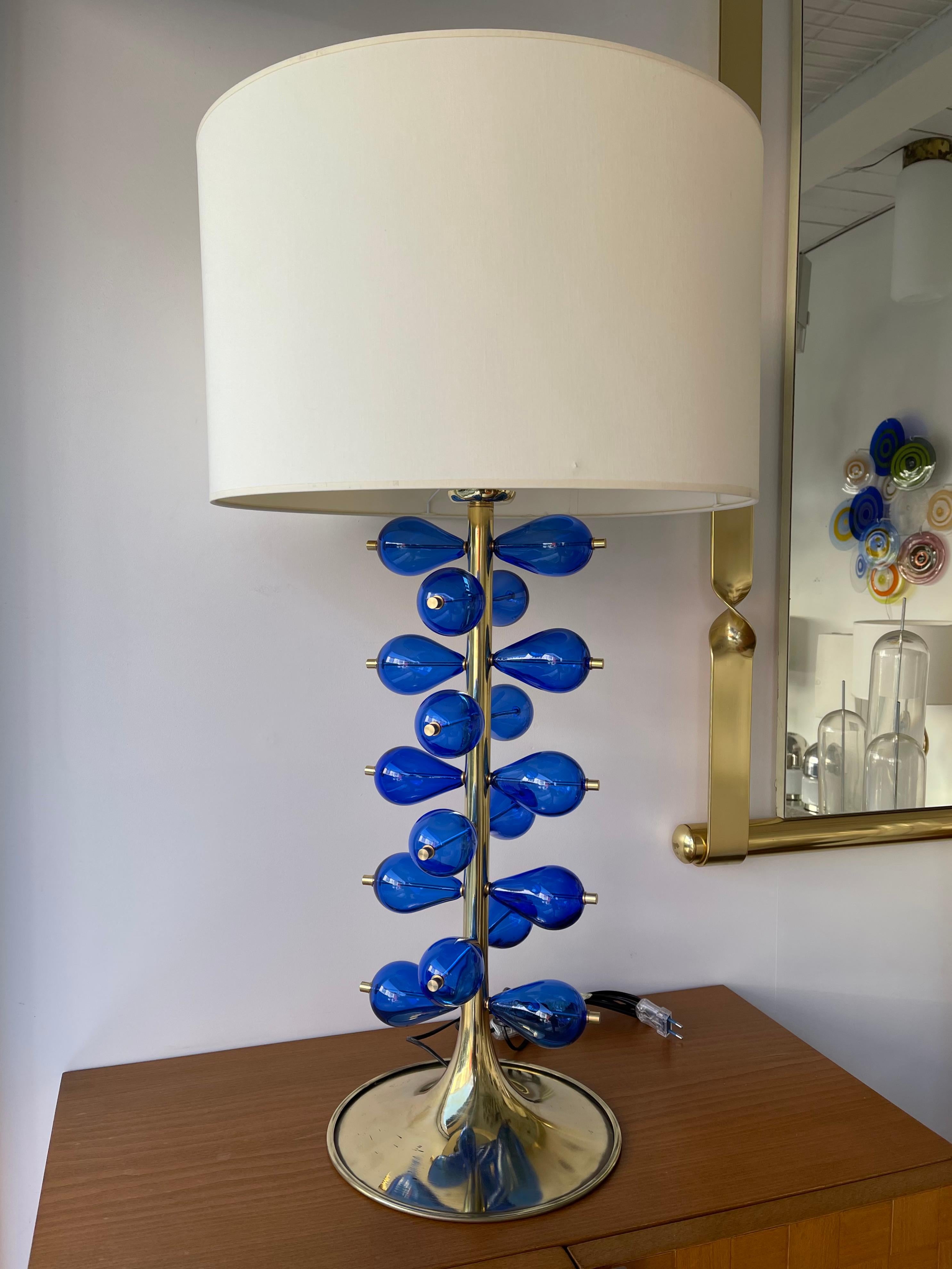 Pair of brass and blue blown Murano glass bubble drop table or bedside lamps. Small Italian workshop production. In the mood of Cenedese, Venini, Vistosi, Seguso, La Murrina.

Demo shades are not included.
Measurements indicated with demo