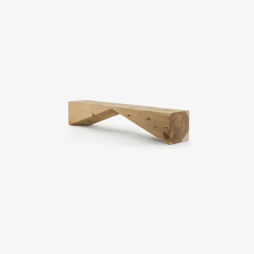 Bench made from a single block of scented cedar that features an original and geometric design.