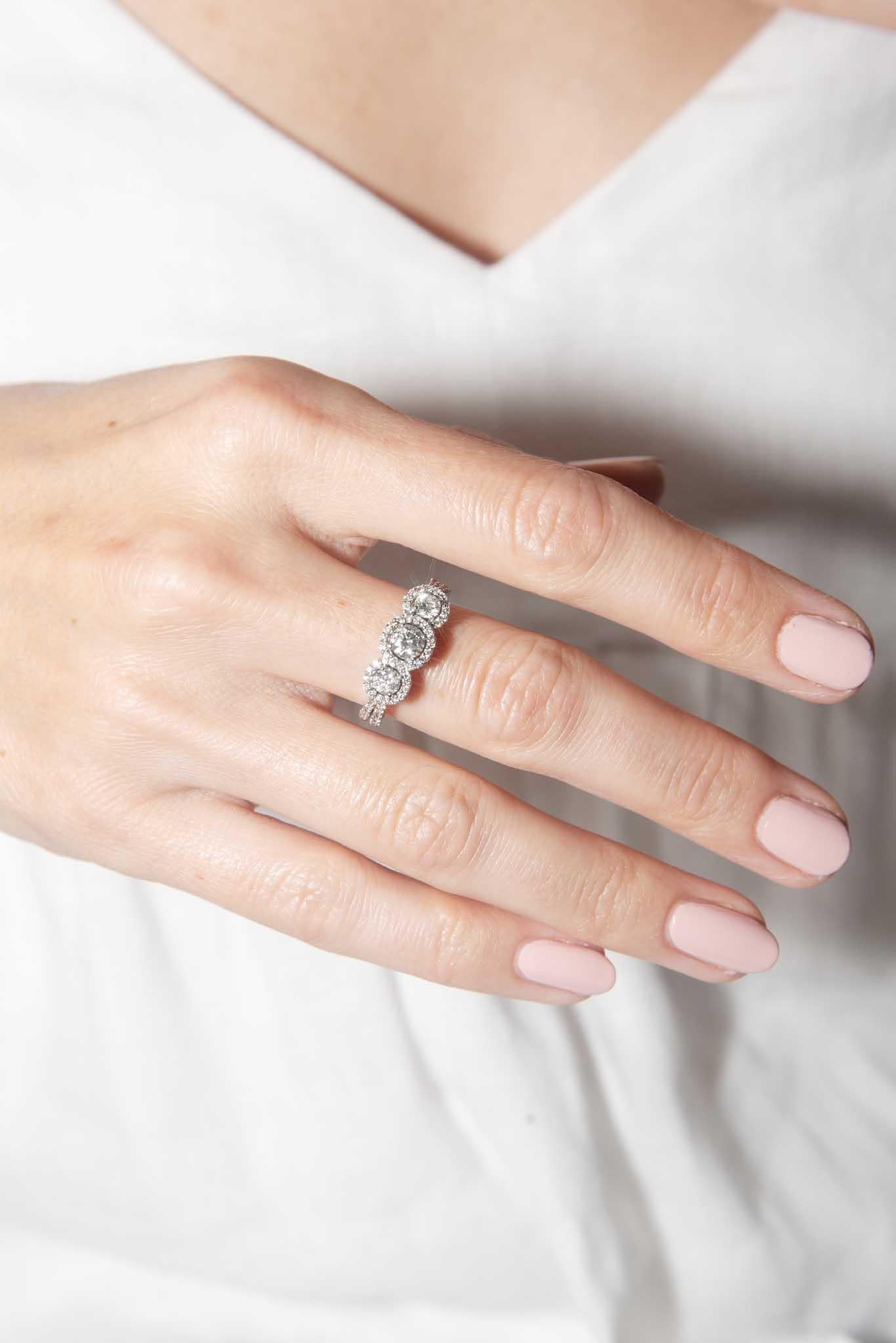 Crafted in 18 carat white gold with haloed clusters of sparkling diamonds, The Zoey Ring is a stunning adornment.  Her shine is perfect for the one who, for you, shines the brightest.

The Zoey Ring Gem Details
The three centre diamonds are