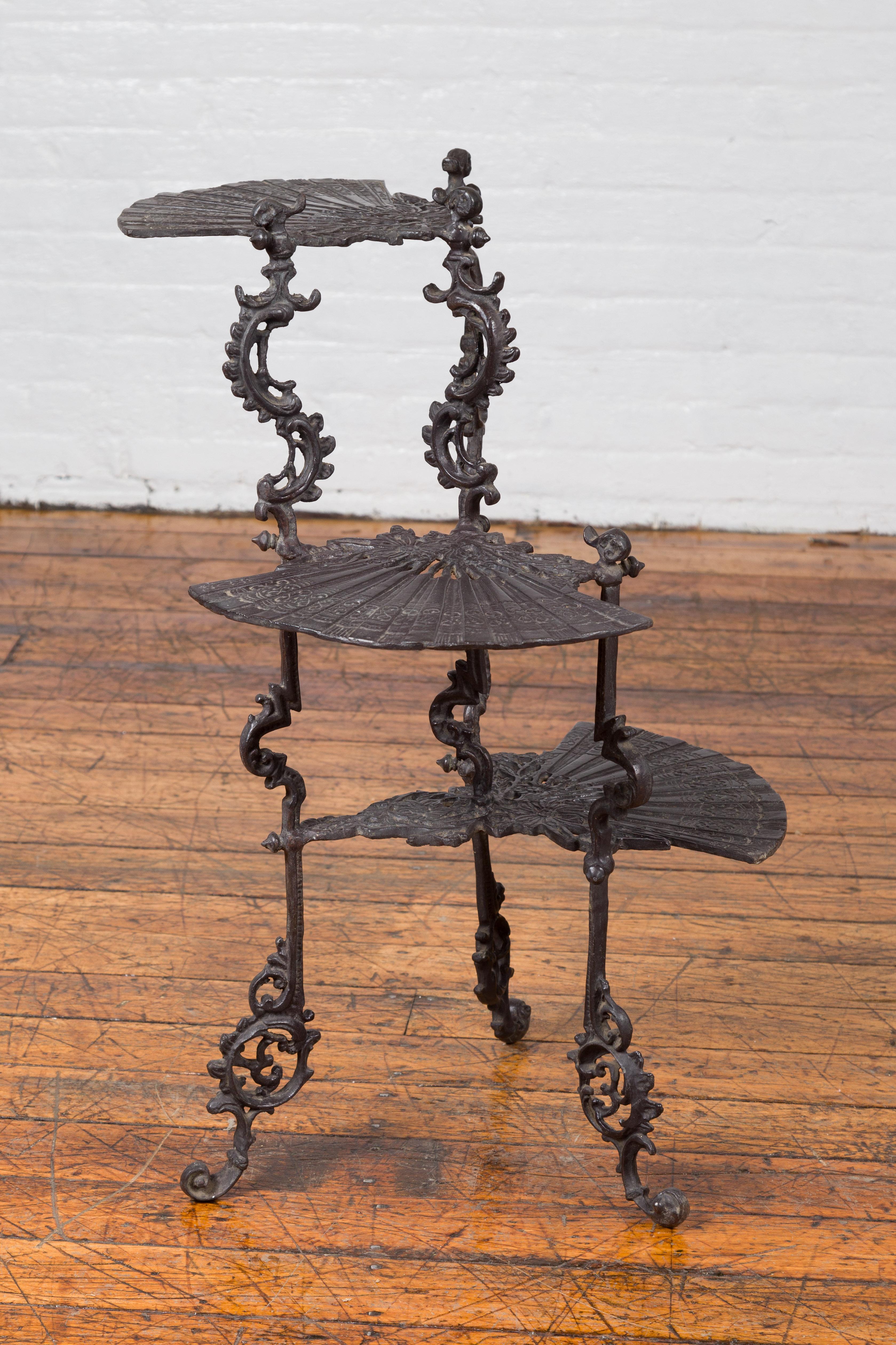 A contemporary bronze display stand with fan shelves and Rococo style scrolling motifs. Created with the traditional technique of the lost-wax (à la cire perdue) that allows a great precision in the details, this display stand captures our attention