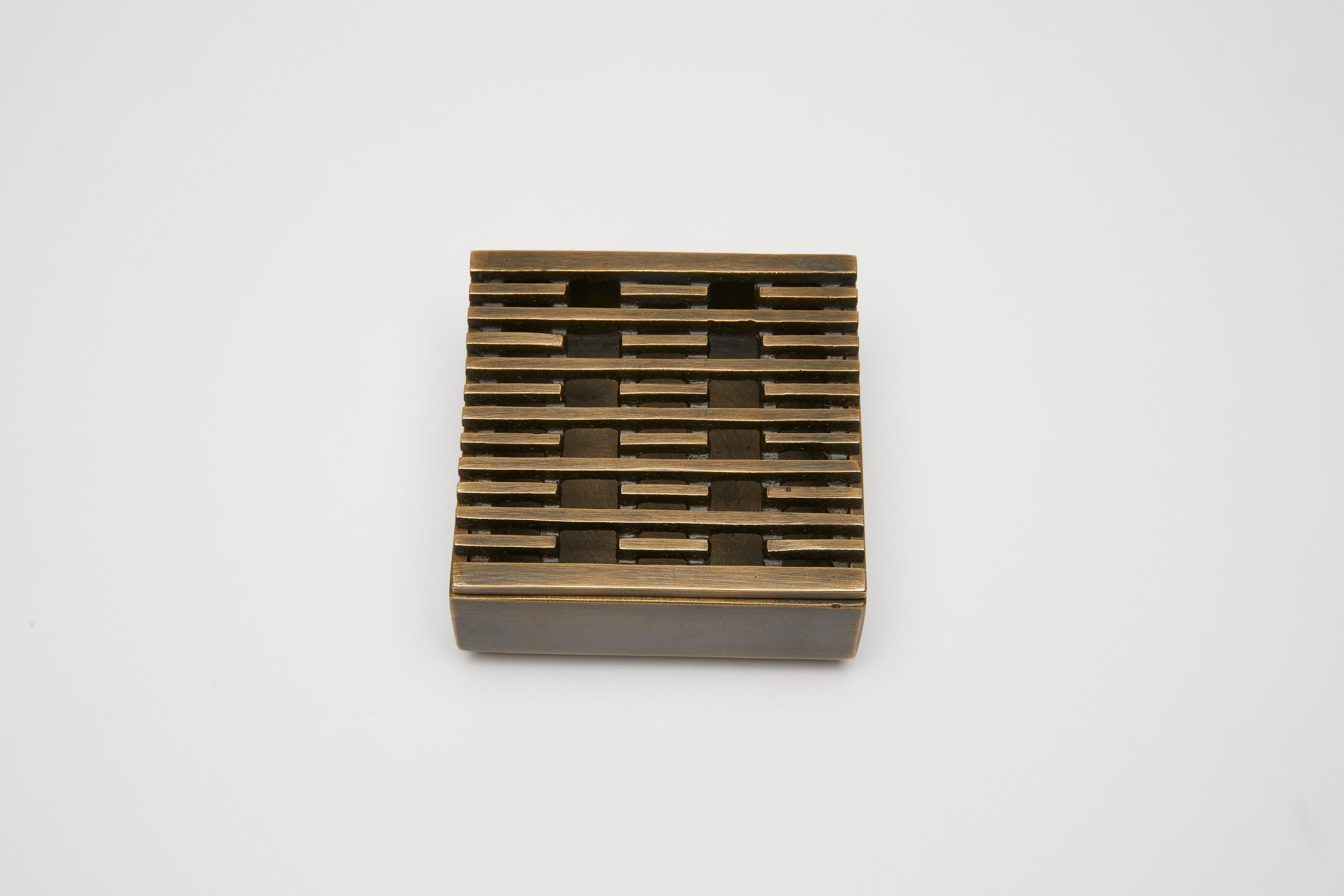 La boîte à encens ou le cendrier en bronze est conçu avec un dessus amovible à motifs. Le motif utilisé ici, une répétition de lignes et de vides, a été développé par Reda Amalou et est utilisé dans plusieurs pièces de la collection Reda Amalou.

La