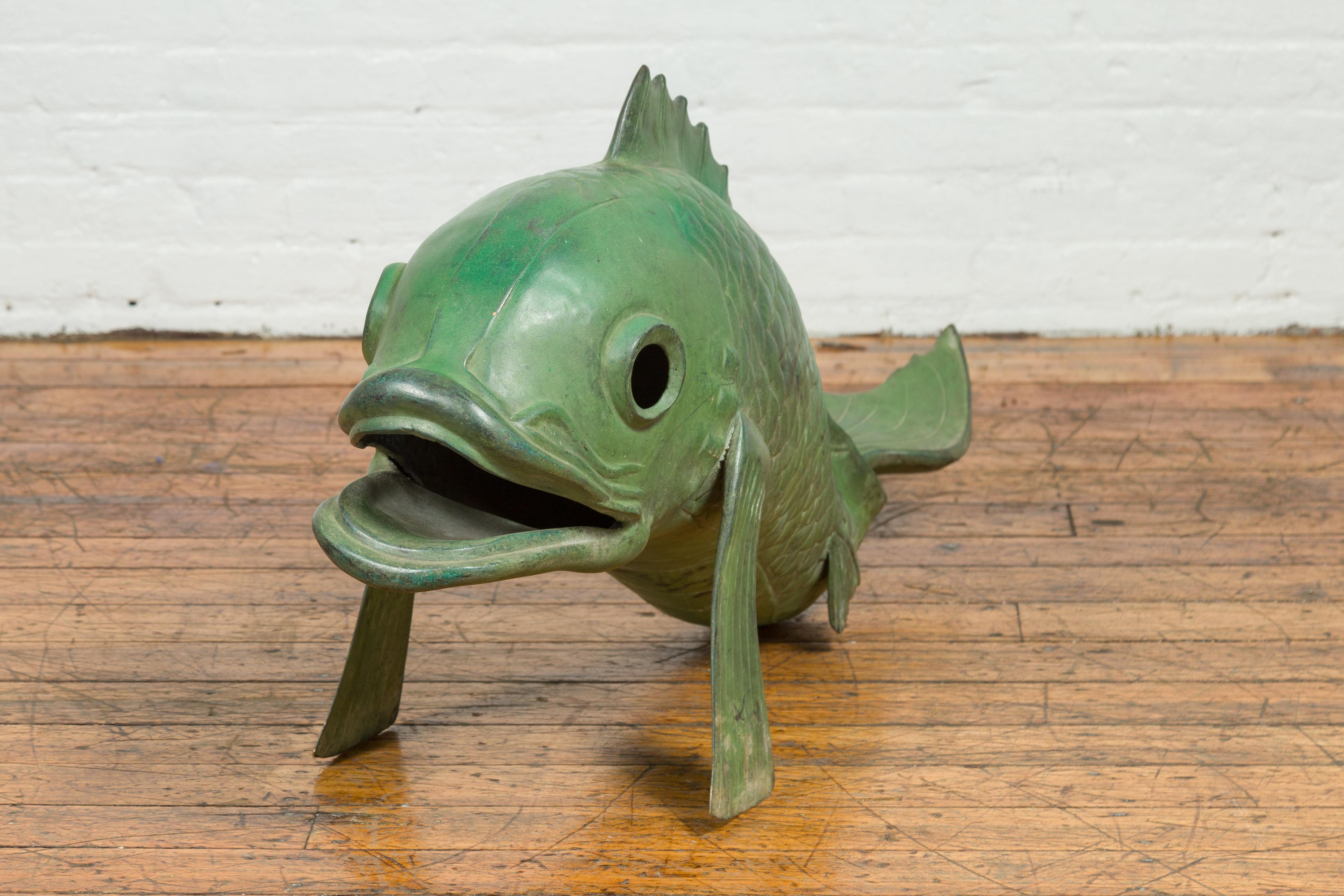 A contemporary bronze swimming carp sculpture with verde patina. Created with the traditional technique of the lost-wax (à la cire perdue) that allows a great precision and finesse in the details, this animal sculpture depicts a carp, raised on its