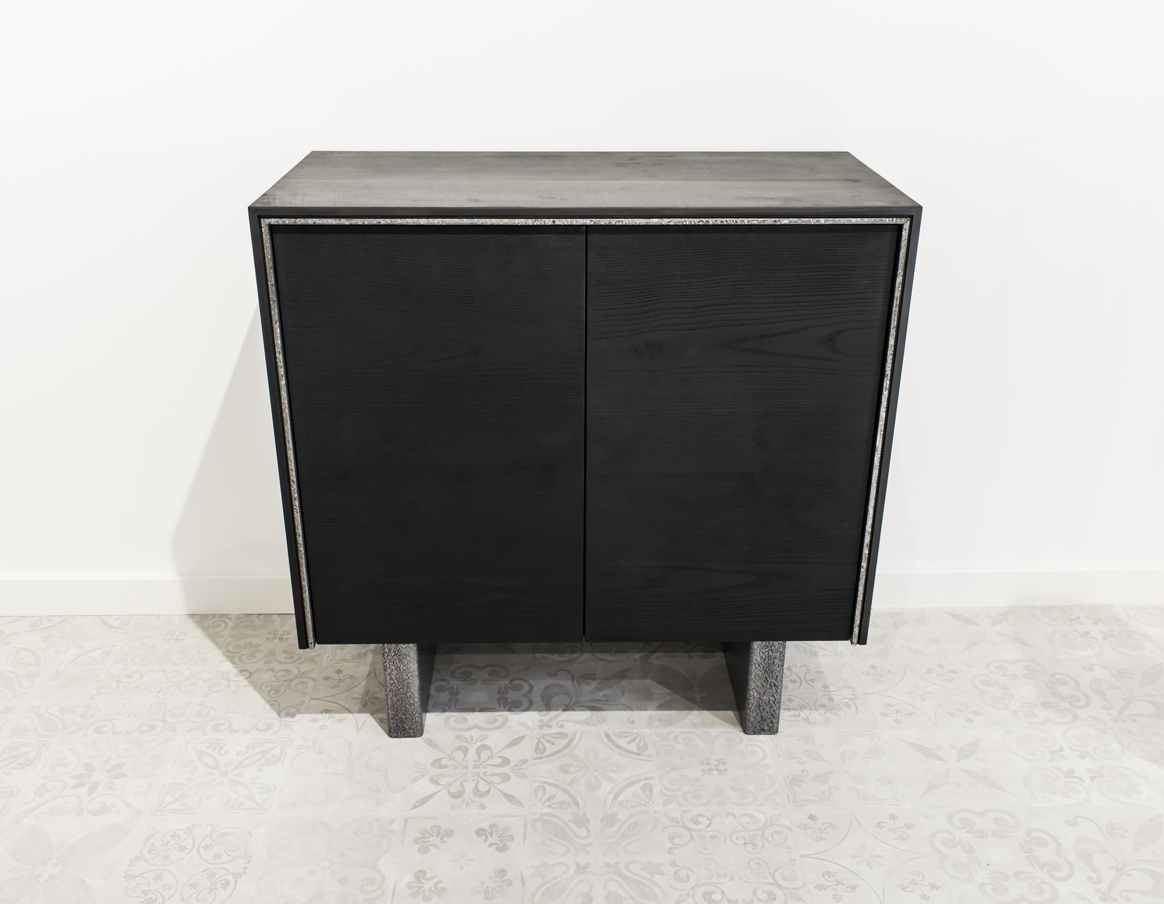 Buffet made entirely of solid ash, features two doors with hammered steel accents. The doors open to reveal three shelves in rare curly ash. An elegant silhouette with perfect dimensions for any home (90 cm wide with a height of 90 cm). This new