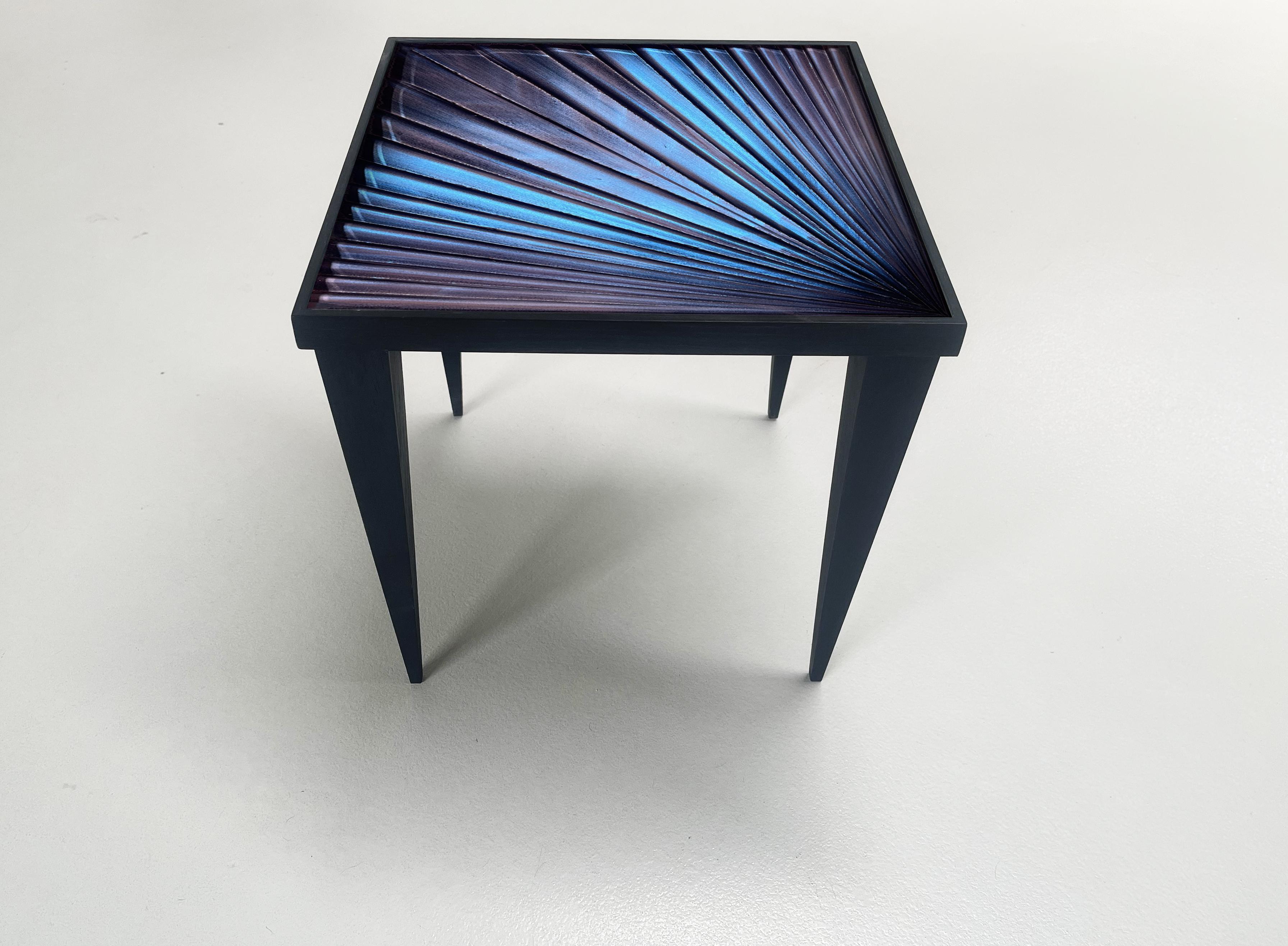 
The ‘Square’ table is innovative and contemporary. 
The support structure is made with oak wood with matt black finish.
The crystal top is hand-engraved at the bottom. The finish of the crystal is blue with pink and purple reflections.
The crystal