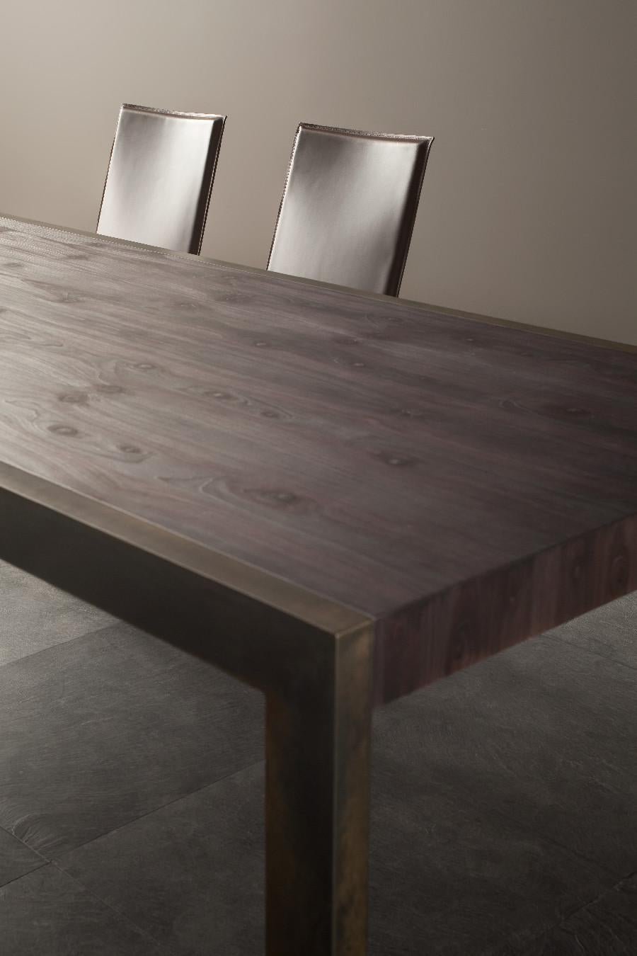 Ein minimalistisches Design, bei dem sich rohes Metall und ultramattes Holz optimal ergänzen und einen echten Charakter verleihen.
Detail des großen Tisches mit Metallbeinen in der Ausführung 085 brüniert und Holzplatte in 103 Black Cypress.
  