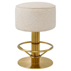 Sgabello da bancone contemporaneo Camari, rivestito in tessuto color crema e con struttura in ottone