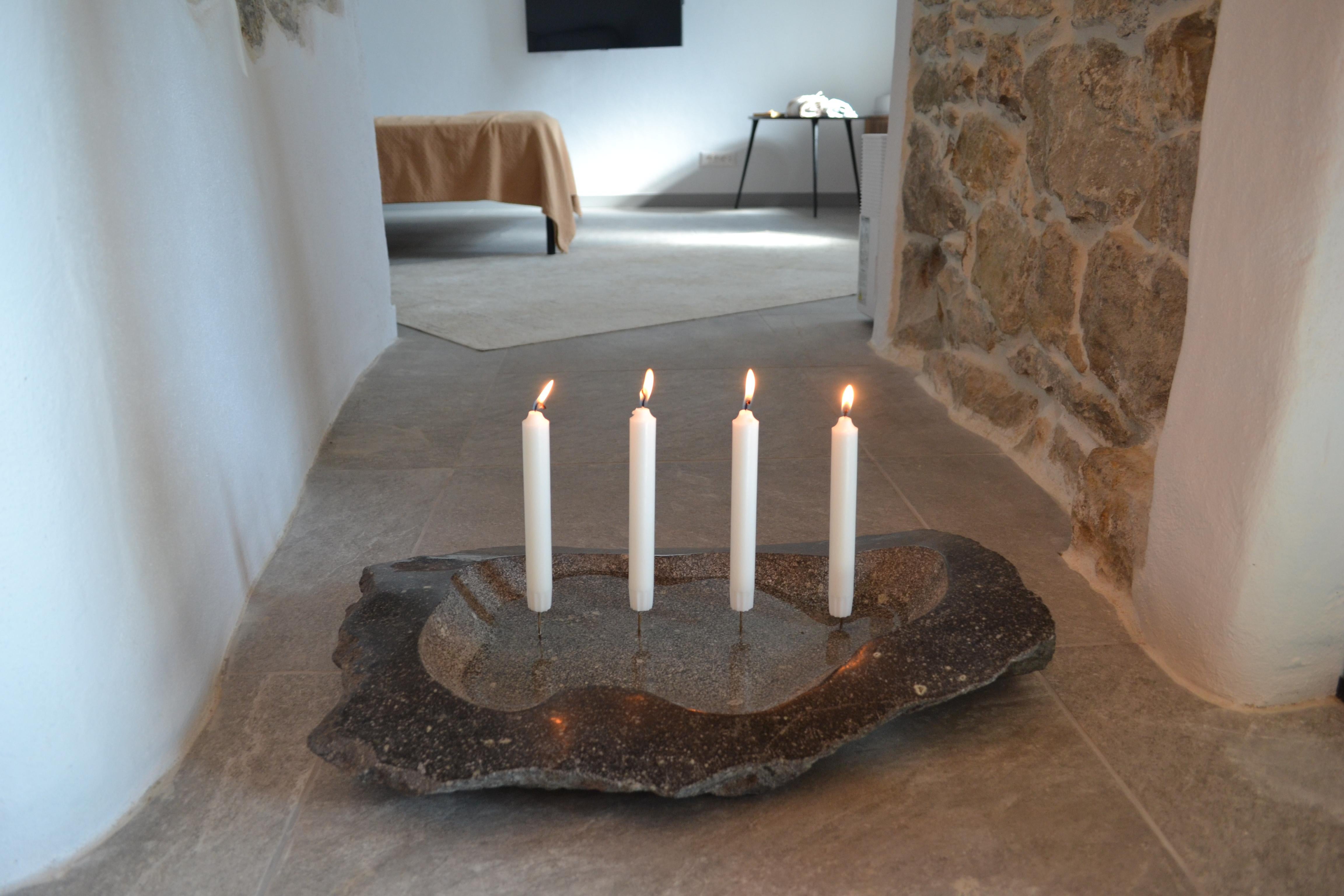 Fire and water. 
A Sculpted candelabra from granite (Rhyolite) stone that can be filled with water.
The objects invites for peaceful contemplation and meditation. 
A single block of granite has been carved in an organic shape to be filled up with