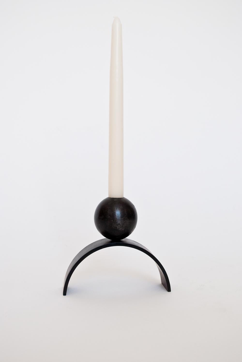 Louis Jobst' arch and ball candle holder. The candle holder is machined from solid steel and patinated black. The candle holder shows off a contemporary form of an arch with a ball / sphere elegantly balancing on top. The design is inspired from