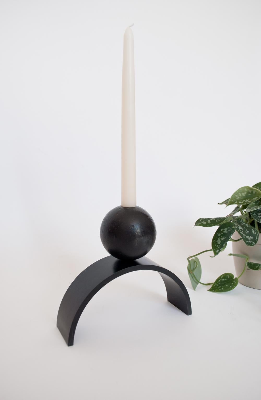 Louis Jobst' Bogen und Kugel extra großer Kerzenhalter. Der Kerzenhalter ist aus massivem Stahl gefräst und schwarz patiniert. Der Kerzenhalter zeigt eine zeitgenössische Form eines Bogens mit einer Kugel, die elegant auf der Spitze balanciert. Das
