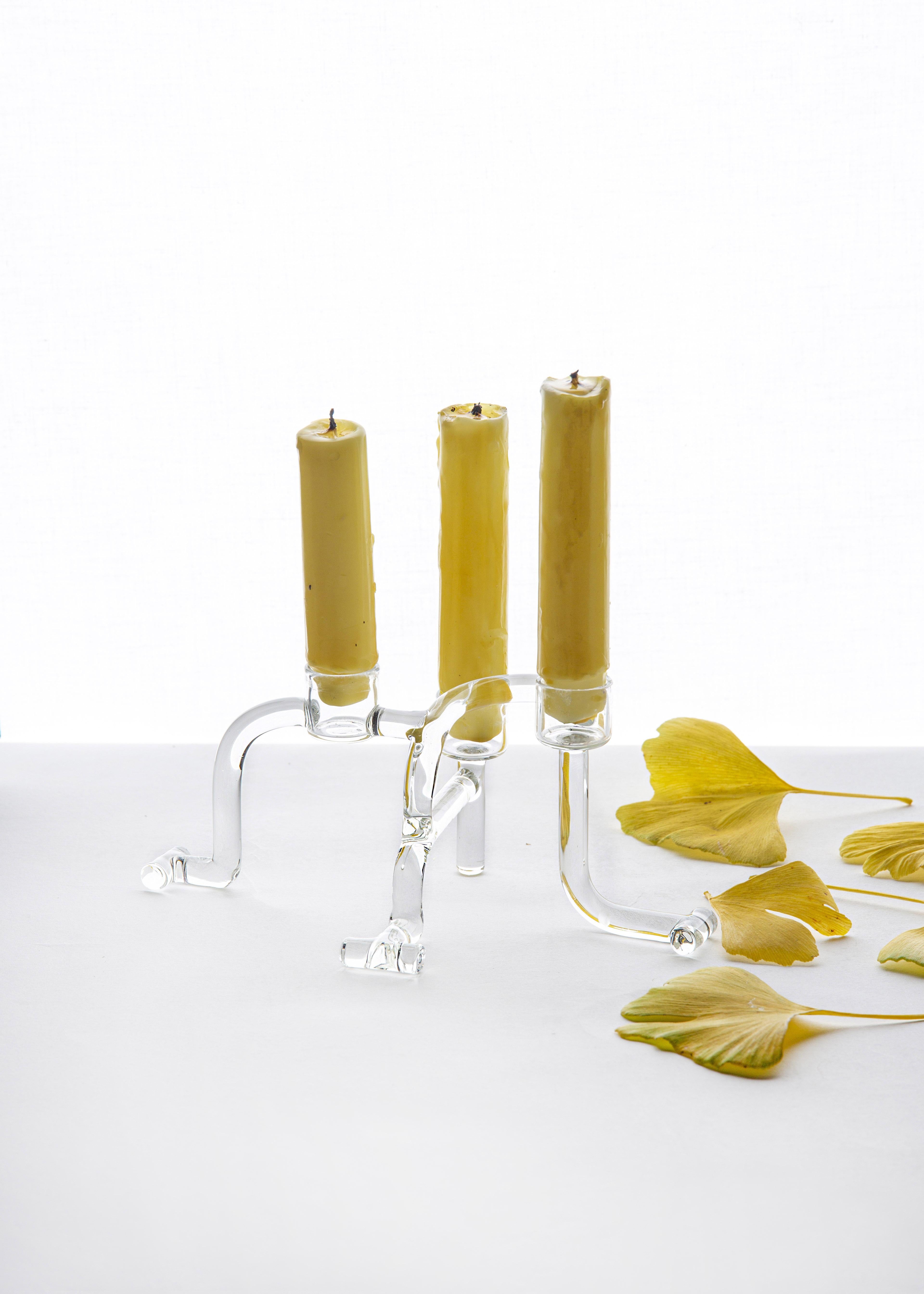 Kerzenständer aus der SiO2 Tableware Kollektion 

Dreiarmiger Kerzenleuchter aus Borosilikatglas. In einem einzigartigen Stück beherbergt dieser moderne und lustige Kerzenhalter 3 klassische Kerzen, die Ihrem Esstisch die richtige Atmosphäre