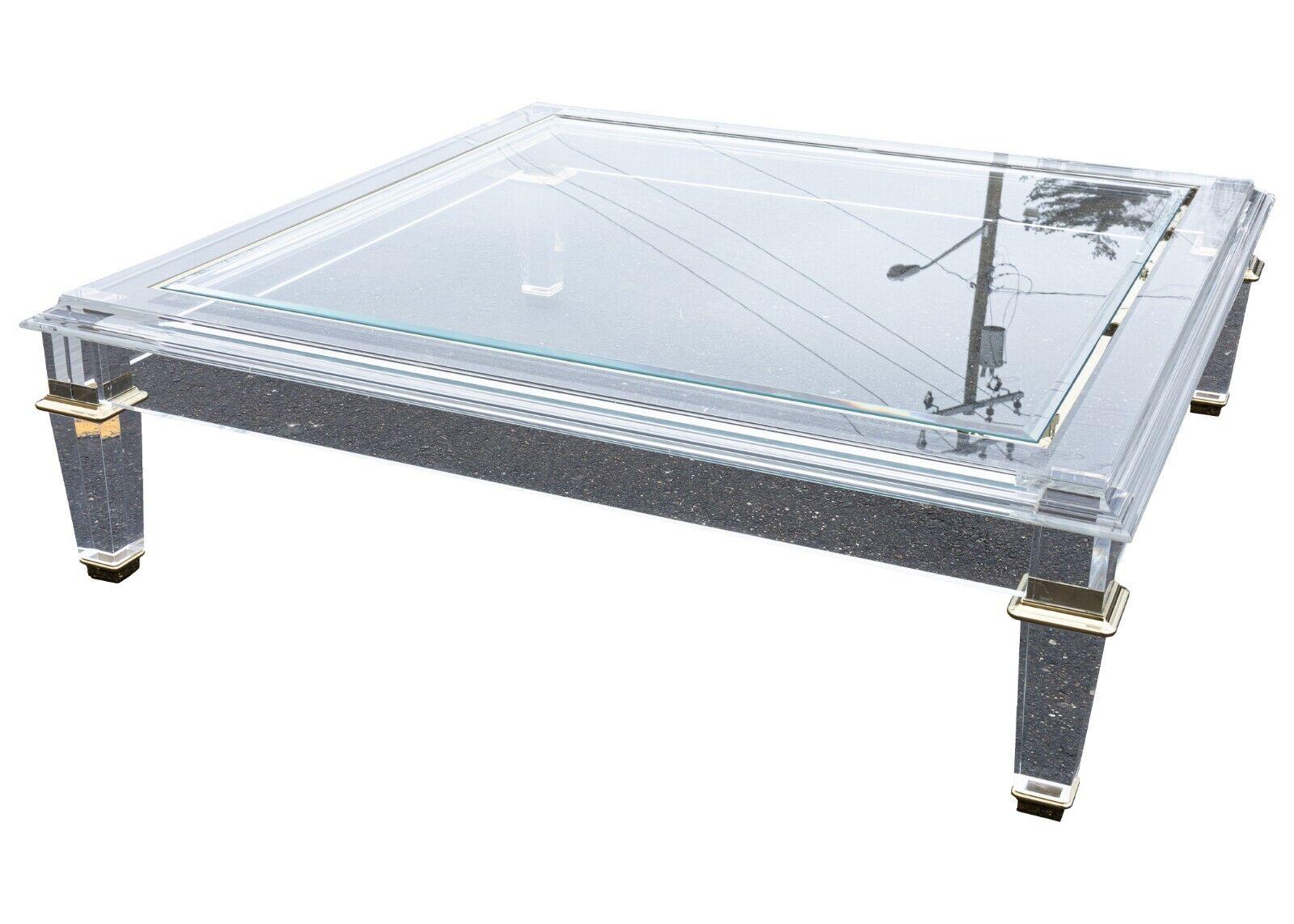 A Caracole Promethean Pierre lucite & glass coffee table. This stunning piece is for any modern furniture lover. The lucite, chrome, and glass construction creates a very unique viewing experience. This table is a great accent piece to add to any