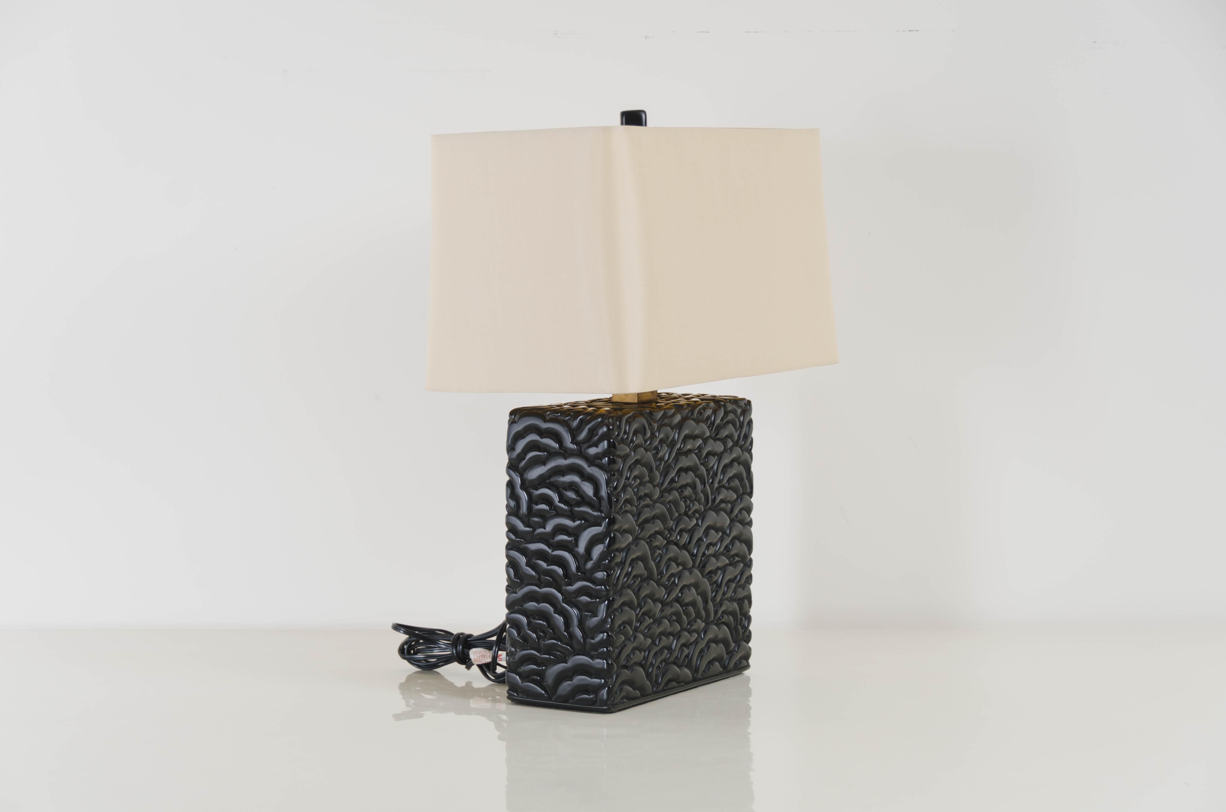 Carved Hua design table lamp
Black lacquer
Hand carved
Metal base
Hand repoussé
Limited edition
Natural linen shade

Repoussé is the traditional art of hand-hammering decorative relief onto sheet metal. This technique involves using a hammer