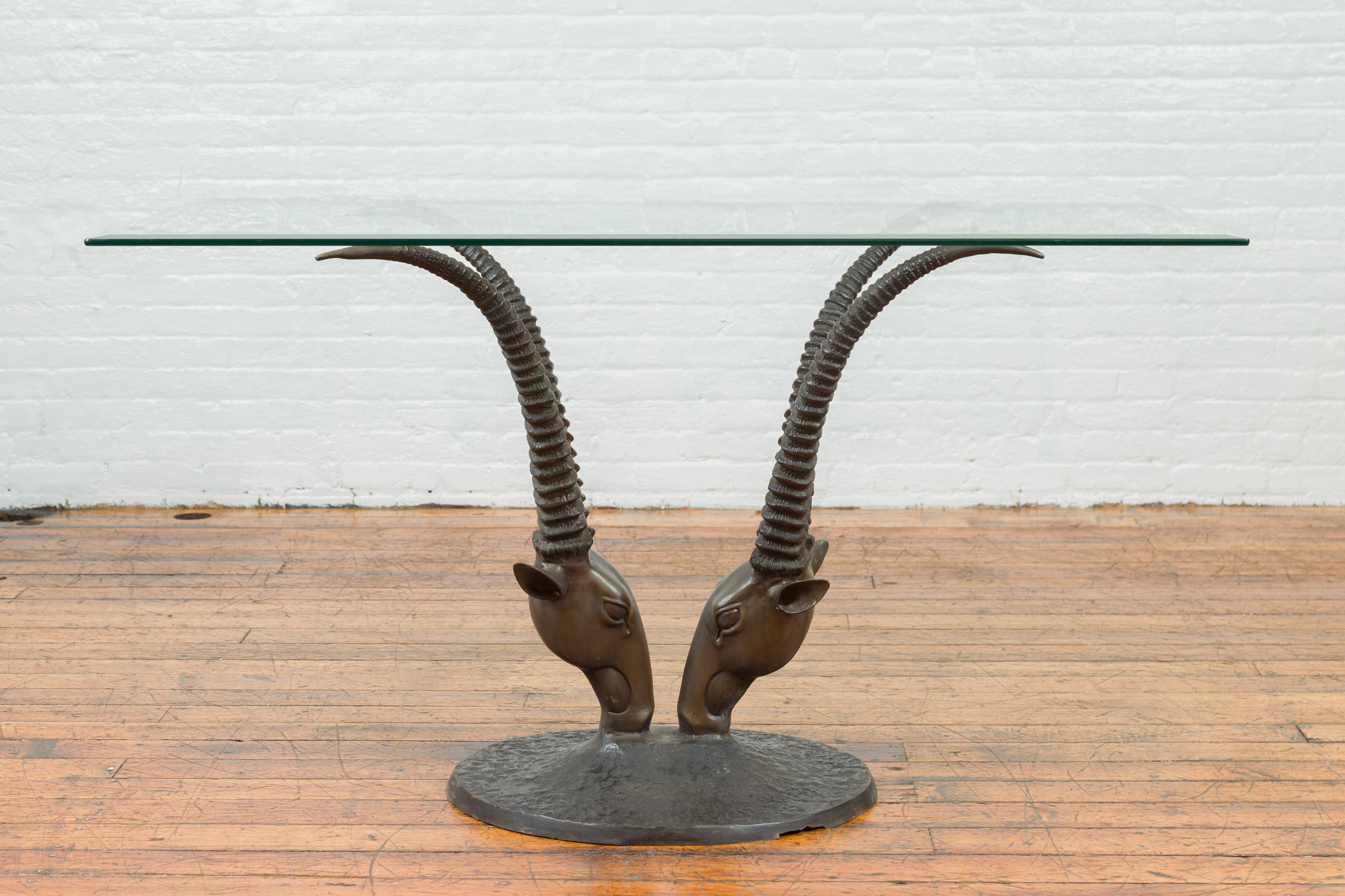 A bronze double antelope dining table base with large antlers and dark patina. Created with the traditional technique of the lost-wax (à la cire perdue), which allows for great precision and finesse in the details, this bronze dining table base