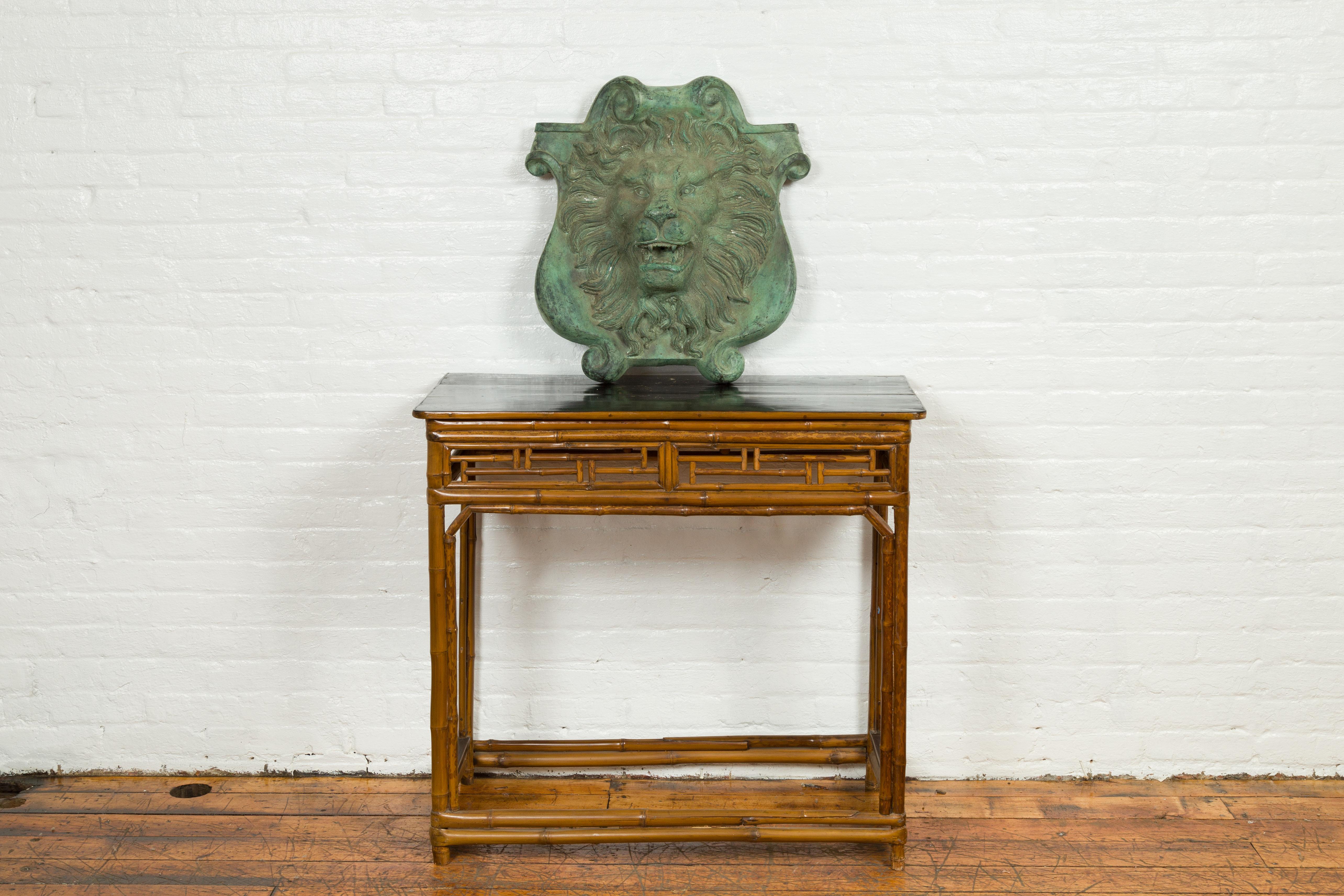 A contemporary bronze lion head wall fountain with Verde patina. Created with the traditional technique of the lost-wax (à la cire perdue) that allows a great precision and finesse in the details, this bronze wall fountain features a roaring lion