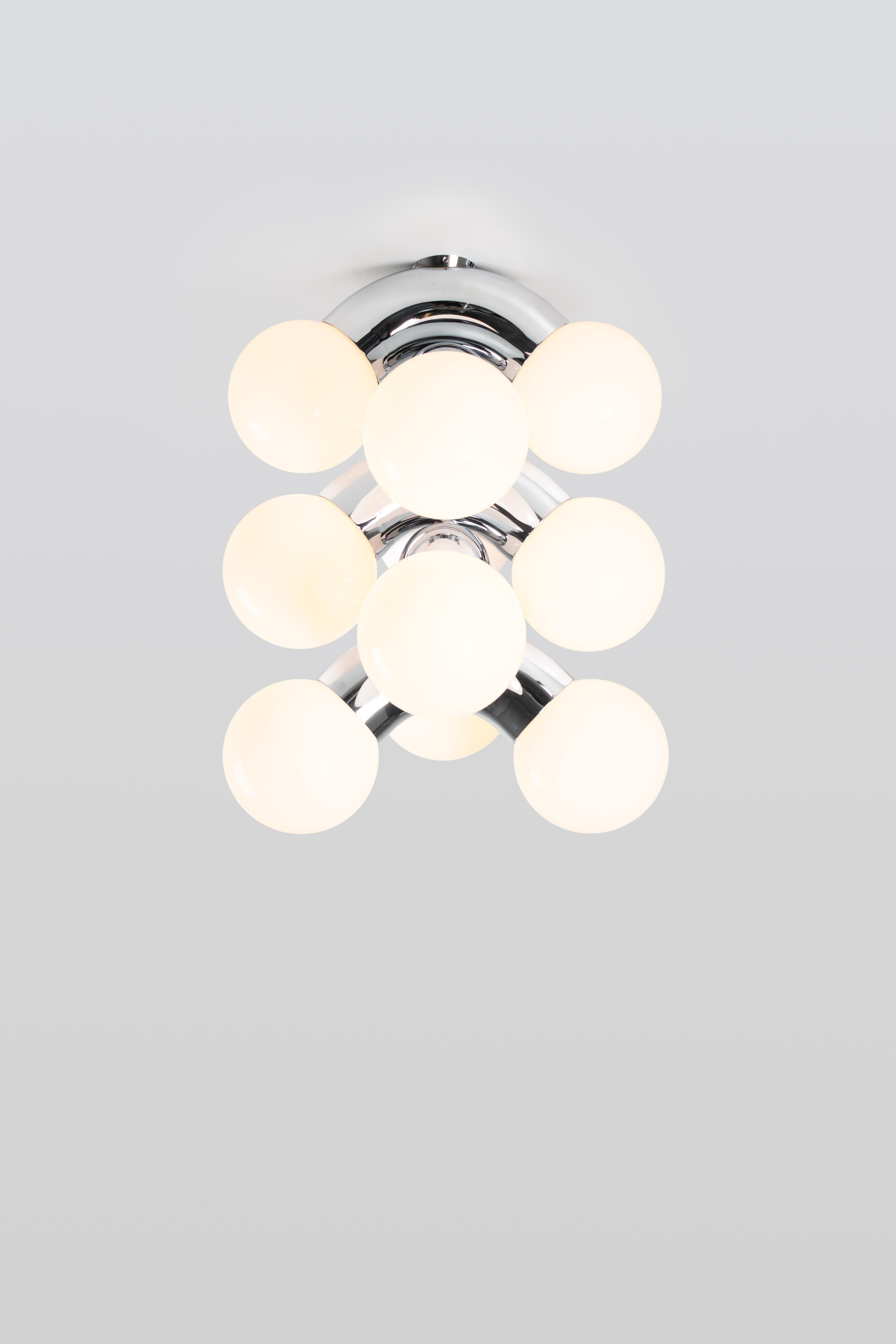 VINE 5-C, ceiling lamp
Design: Caine Heintzman, Editor: ANDLight

The vine ceiling lamp combines exaggerated form with the propensity for repetition resulting in an ambitious vertically scaling fixture.

Materials
– Chromed steel
– Opal glass