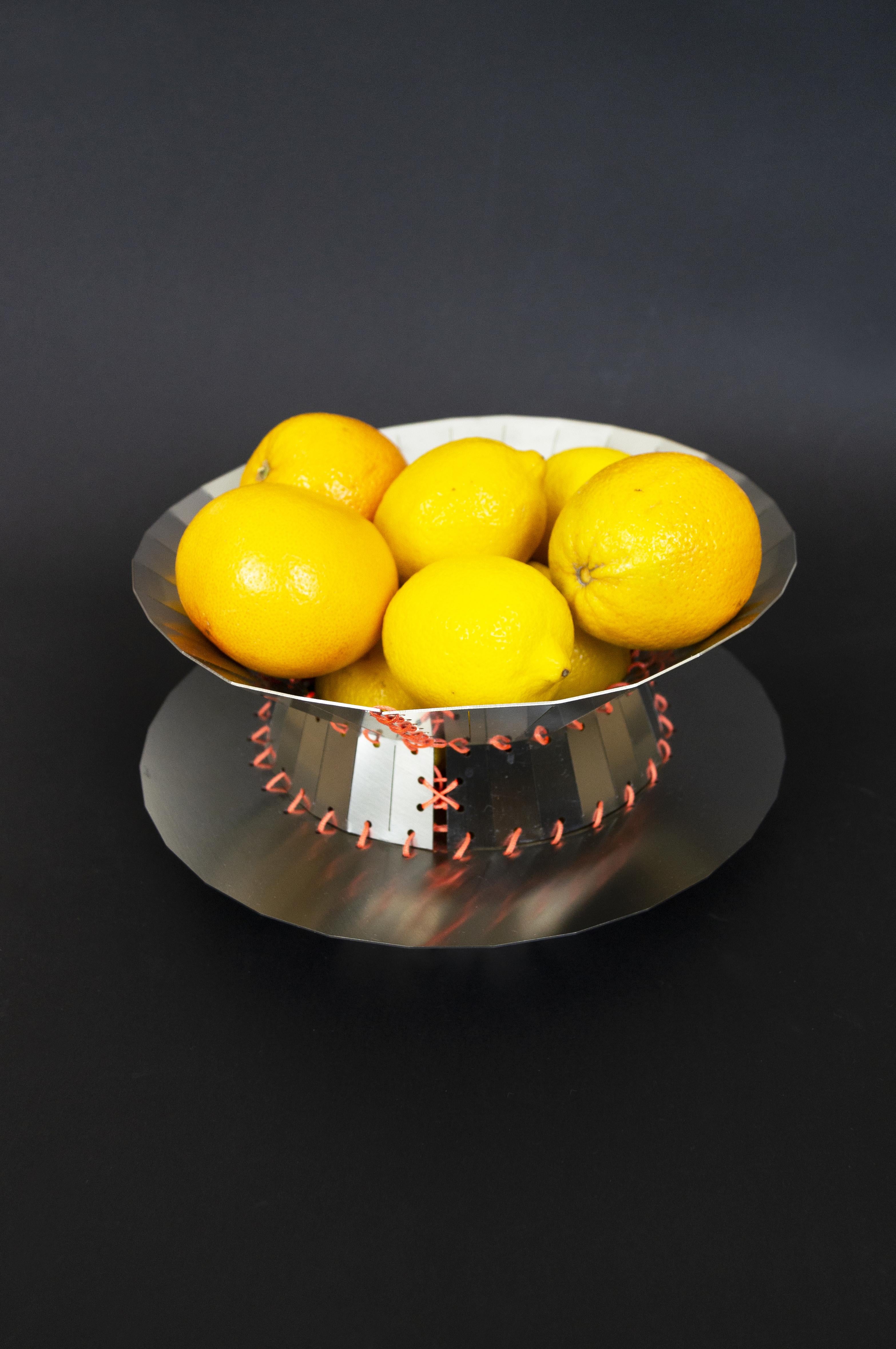 Stainless steel centerpiece from the Minas collection designed by StudioNotte. This tray with clean and multifaceted shapes is assembled with rope stitching. 
Minas whole collection consists of two centerpieces and a tray. These steel sheet