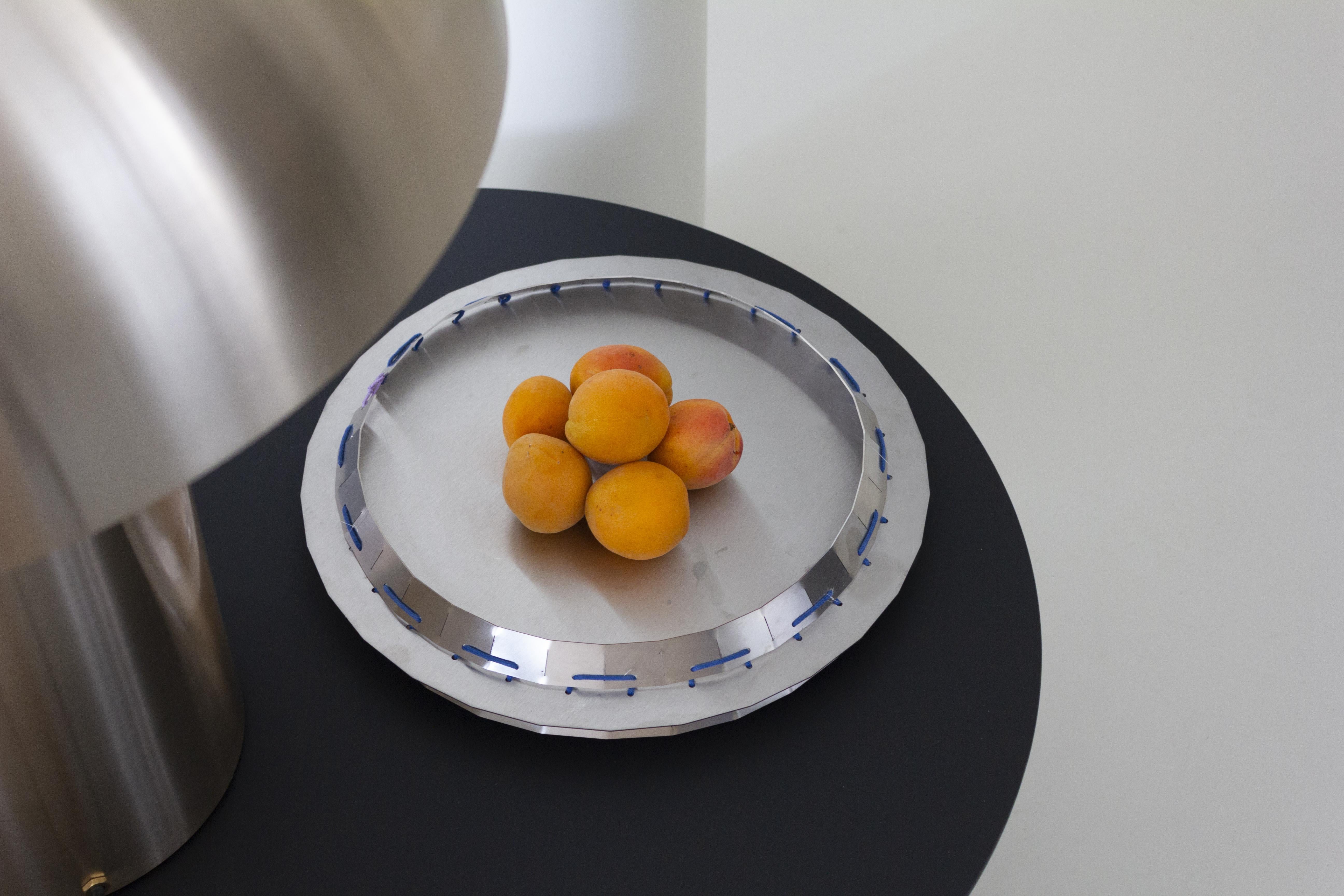 Stainless steel tray or centerpiece from the Minas collection designed by StudioNotte. This tray with clean and multifaceted shapes is assembled with rope stitching. 
Minas whole collection consists of two centerpieces and a tray. These steel sheet