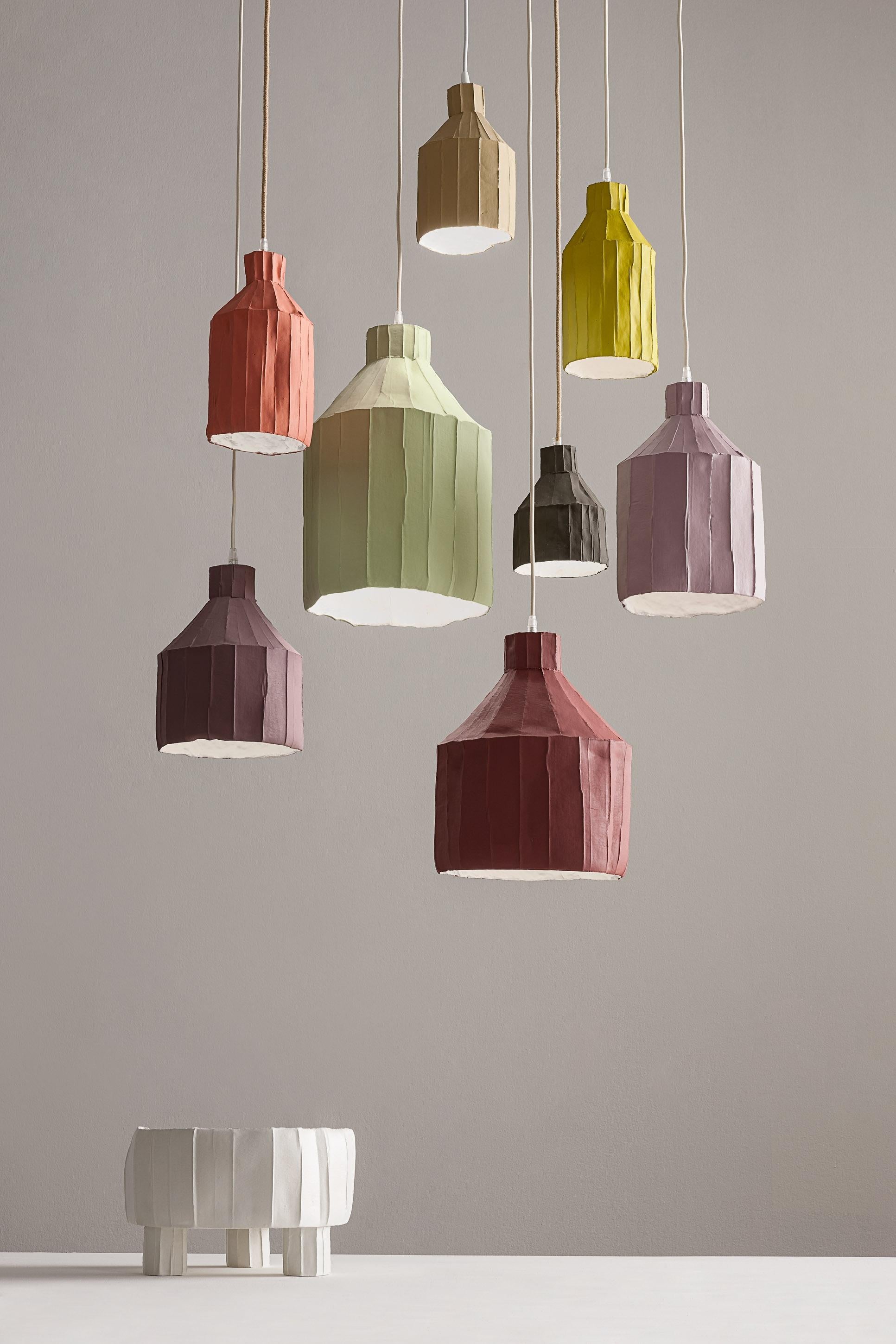 Questa sofisticata lampada è una testimonianza del design innovativo e della superba maestria delle opere d'arte in cartapesta di Paola Paronetto.  Interamente realizzato a mano, questo pezzo prende vita utilizzando l'argilla di carta, una miscela