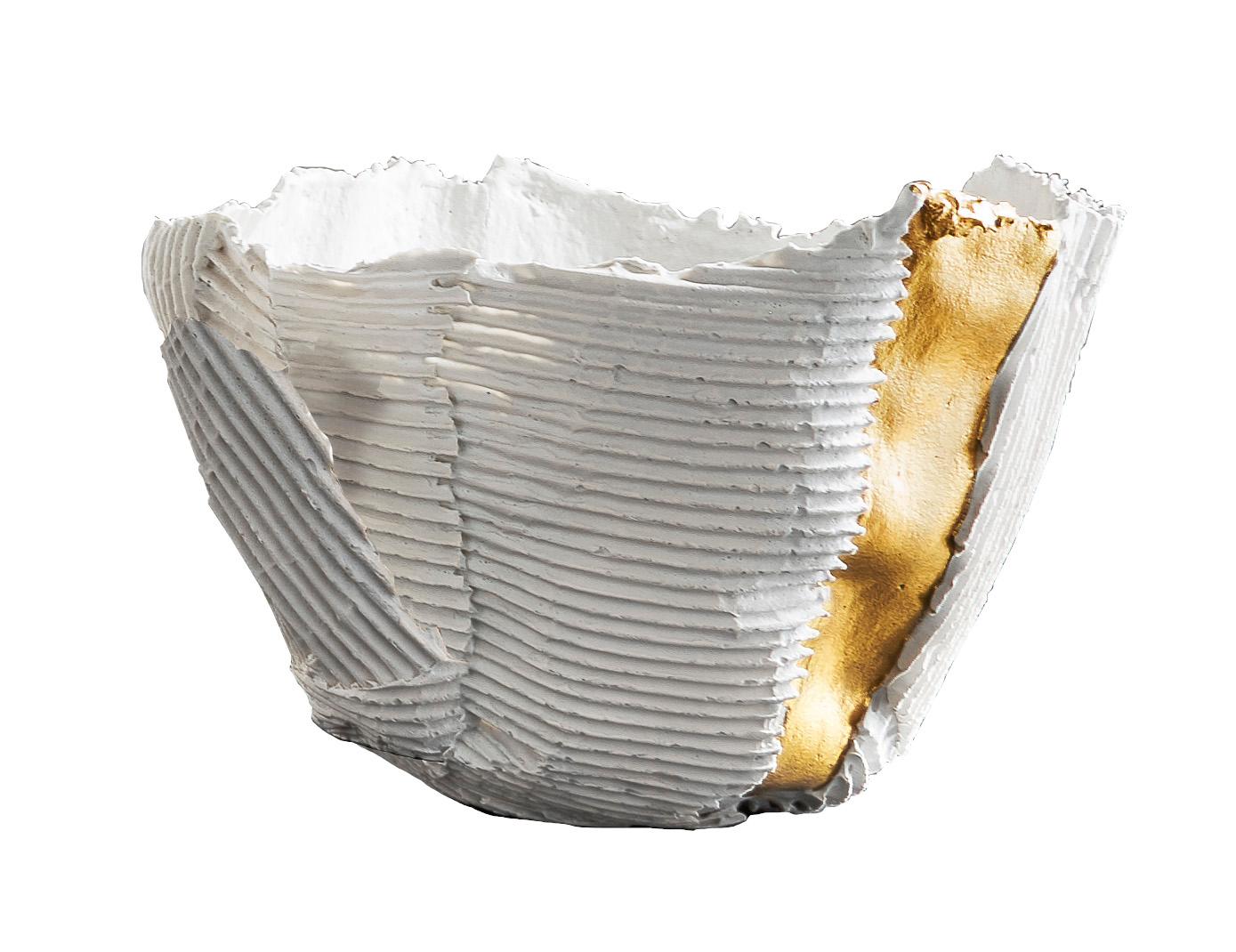 Striking and stately, this bowl features dynamic horizontal and vertical ridges and a distinctive panel insert in gold, whose vibrant color and smooth surface elegantly contrast with the expressive white for a striking visual impact. Taking on an