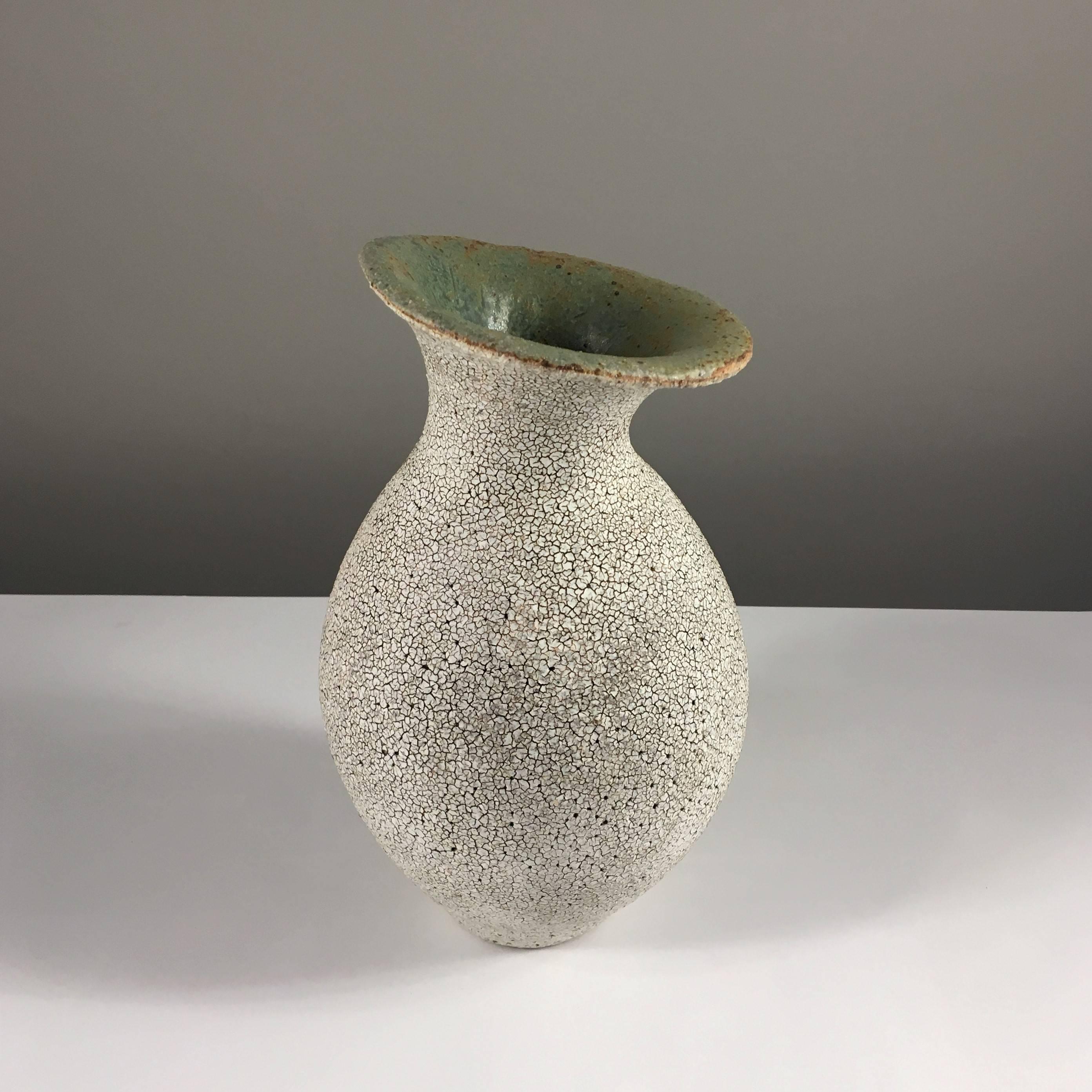 Contemporary ceramic artist Yumiko Kuga's glazed stoneware curved neck vase no. 161 is part of her Crackle series. All of the pieces in this series are hand-built and 100% handmade so they are one-of-a-kind and thus vary slightly from one another.