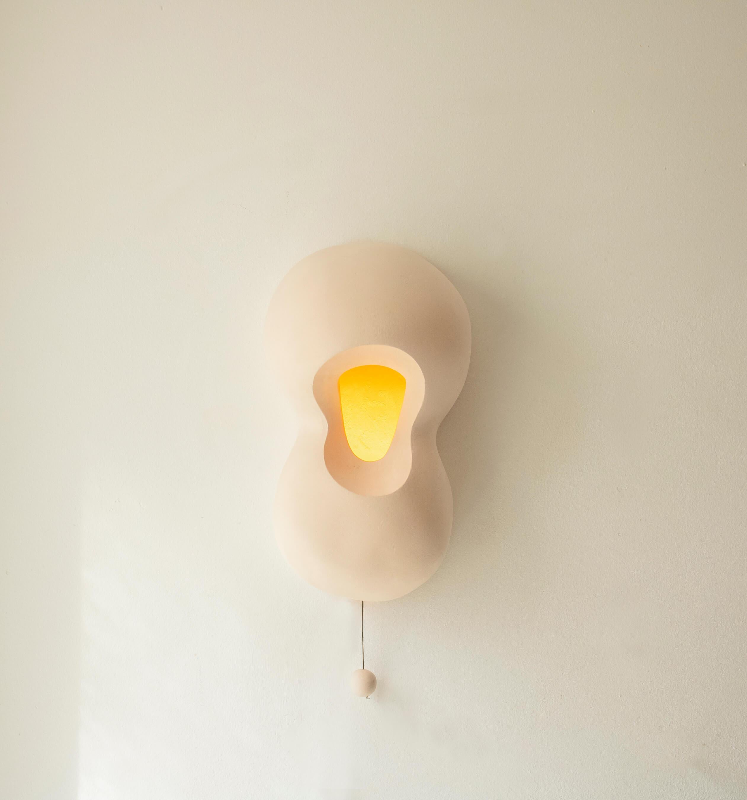 Bubble Lamp is a sculptural ceramic lamp - sconce. The Bubble Lamp stands out for its unique sculptural form and practical features. Crafted from ceramic, its organic shape and abstract contours offer an intriguing visual appeal. With its