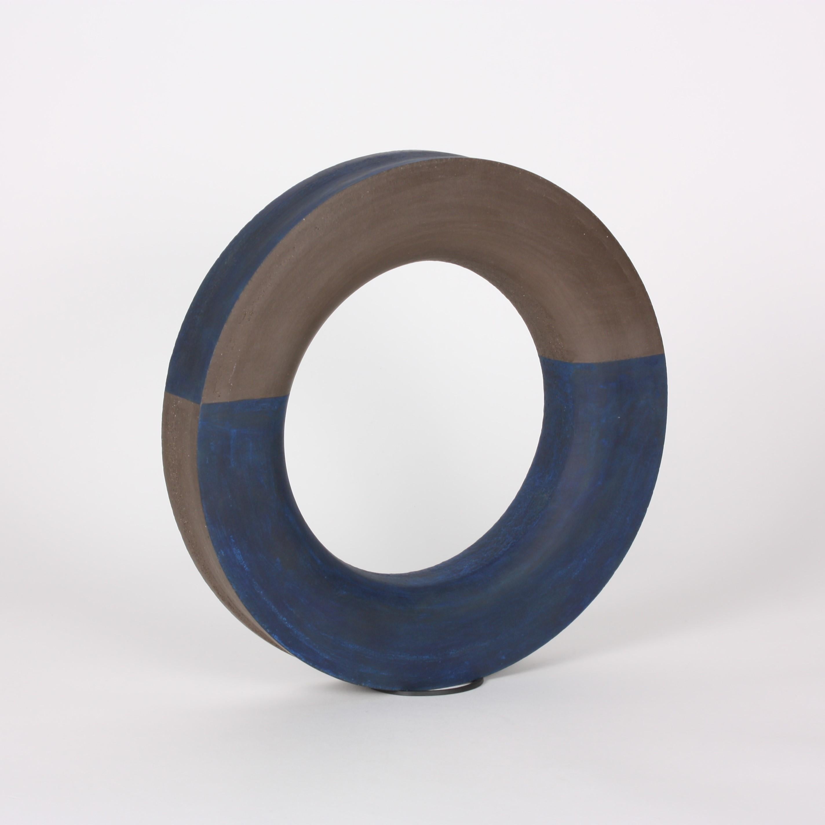 Contemporary ceramic ring sculpture in a rich cocoa/velvety brown stoneware vibrates with accents of blue slip along the outer rim and on the smooth bottom arch. Wheel-thrown sculpture, 27 cm in diameter.

One-of-a-kind.

Signed by the